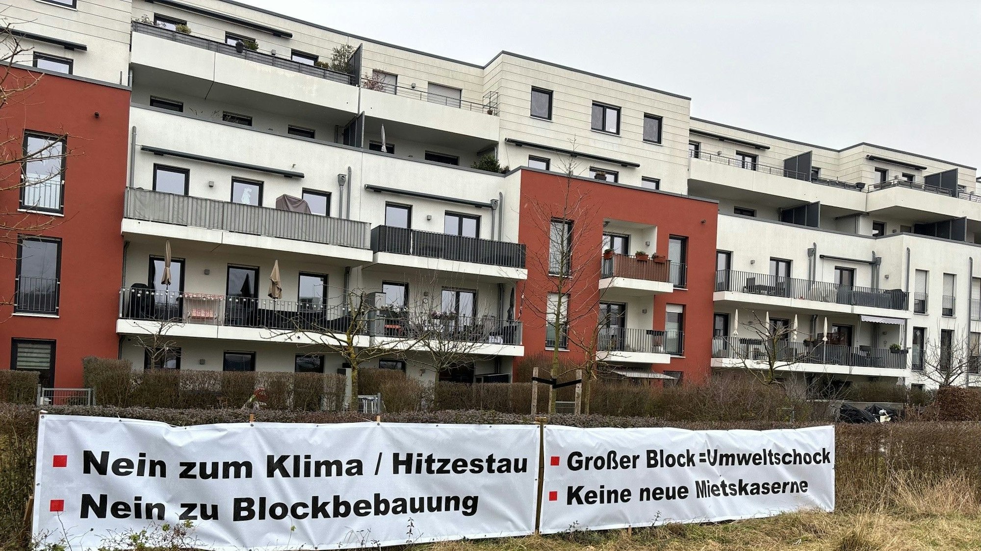 Auf dem Bild sind Wohnhäuser und Protest-Transparente zu sehen.