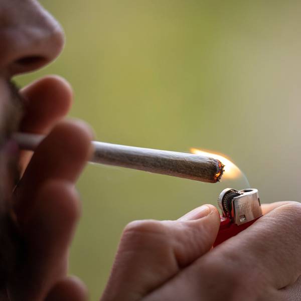 Ein Mann zündet sich einen Joint an. (Symbolbild)