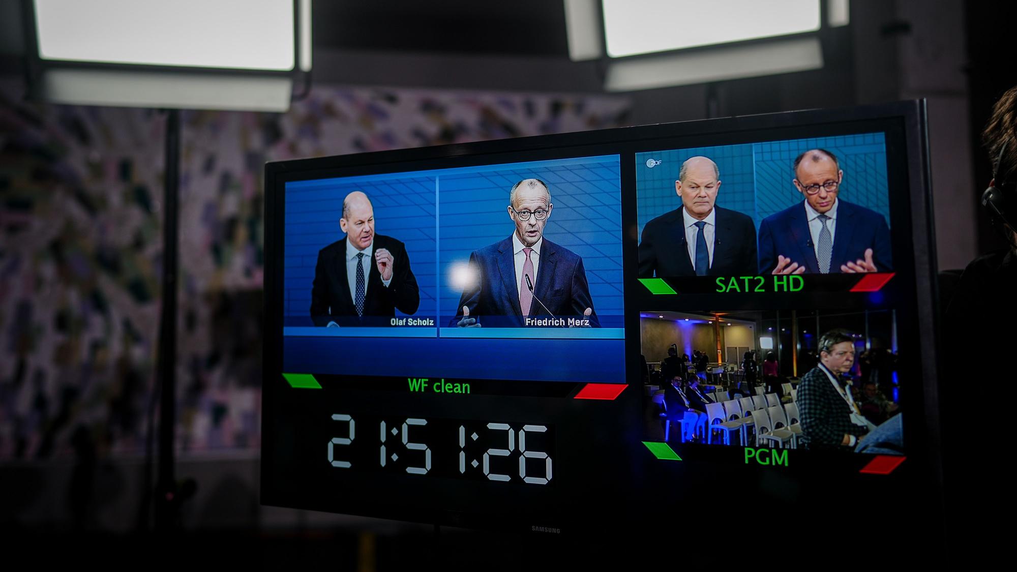 Nach dem TV-Duell von ARD und ZDF sind Bundeskanzler Olaf Scholz (l, SPD) und Friedrich Merz, Unions-Kanzlerkandidat und CDU-Bundesvorsitzender, im Studio Berlin-Adlershof auf einem Monitor zu sehen.