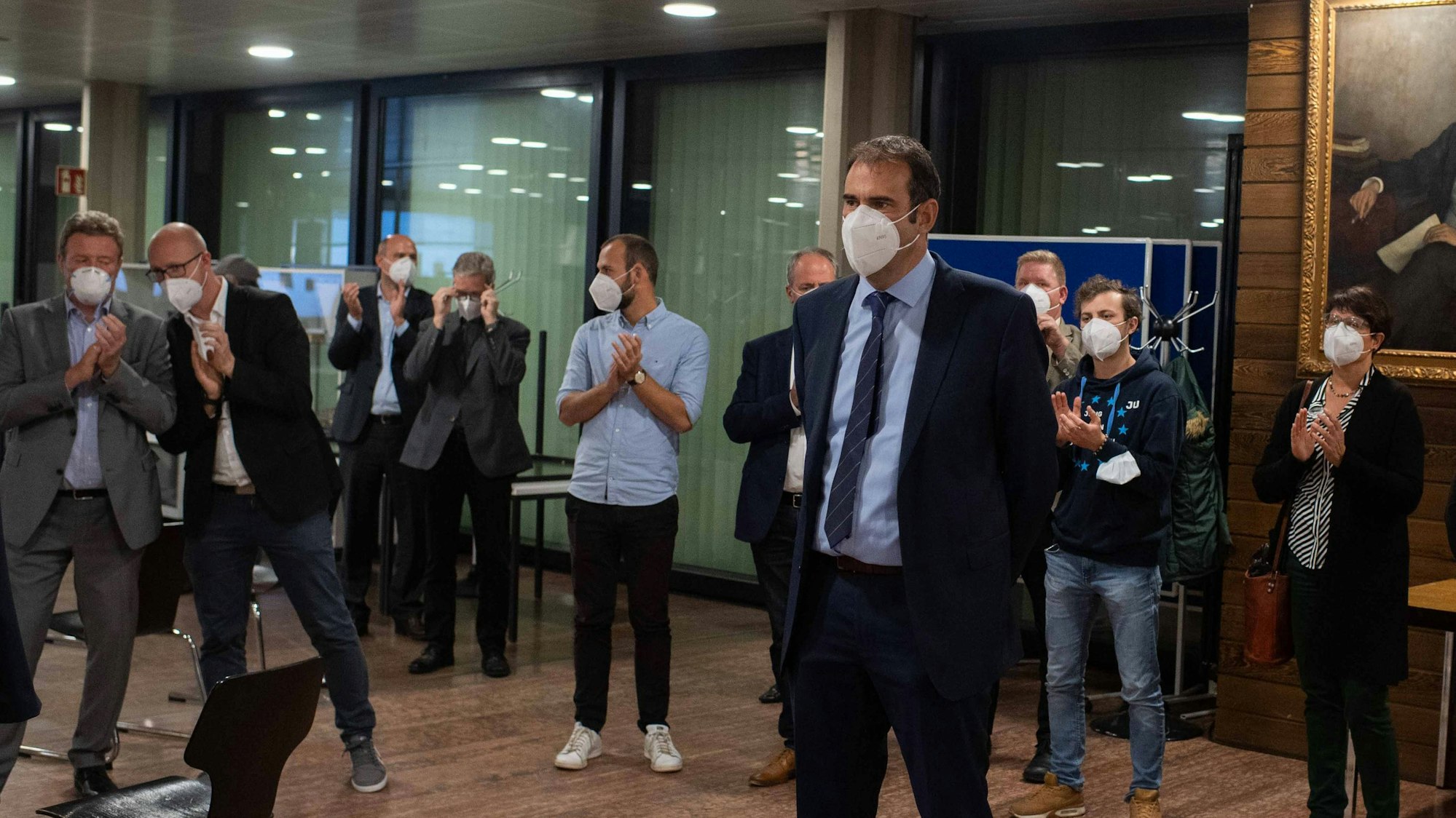 Das Bild zeigt eine Szene vom Wahlabend 2020. Johannes Winckler steht vorne, mehrere CDU-Mitglieder haben einen Halbkreis um ihn gebildet und applaudieren ihm. Alle tragen Corona-Schutzmasken.