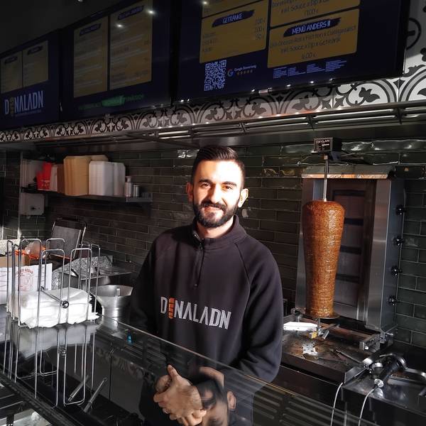 Ein Mann steht hinter der Theke eines Döner-Imbisses