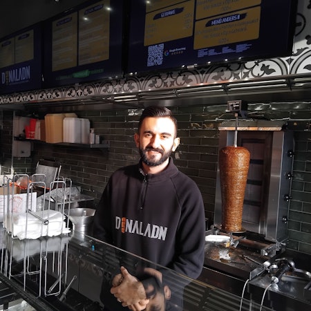 Ein Mann steht hinter der Theke eines Döner-Imbisses
