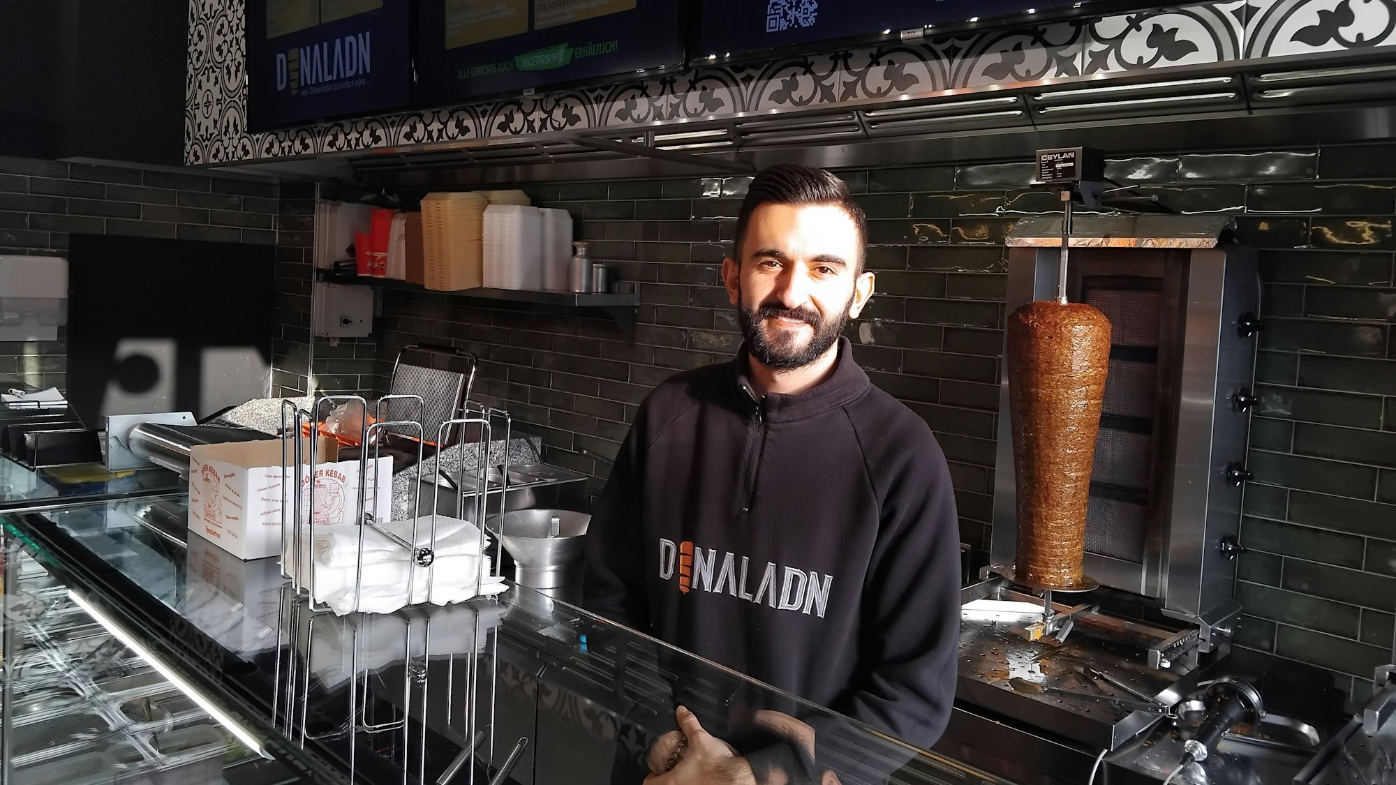 Ein Mann steht hinter der Theke eines Döner-Imbisses