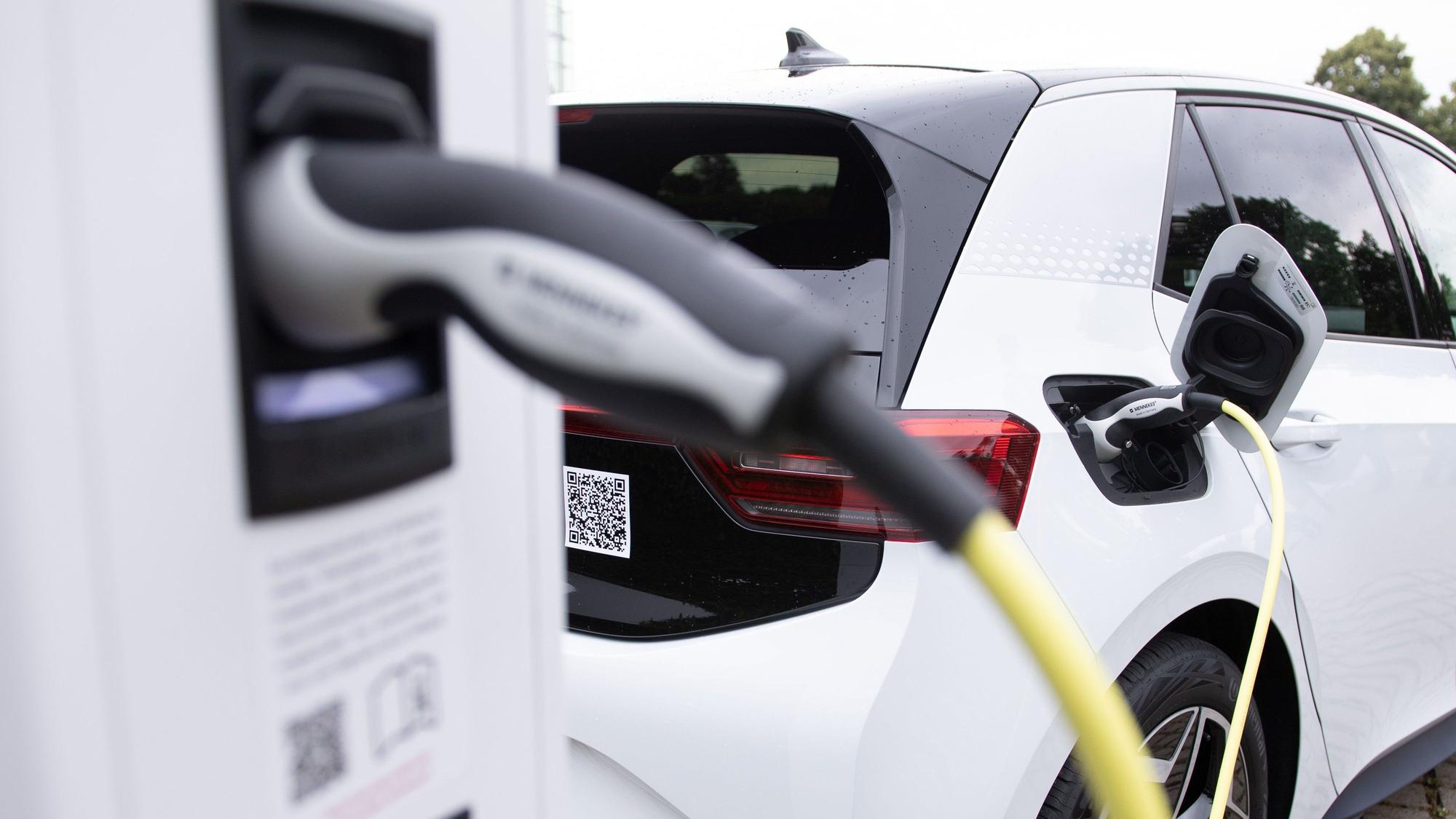 Ein weißes E-Auto an einer Ladestation.