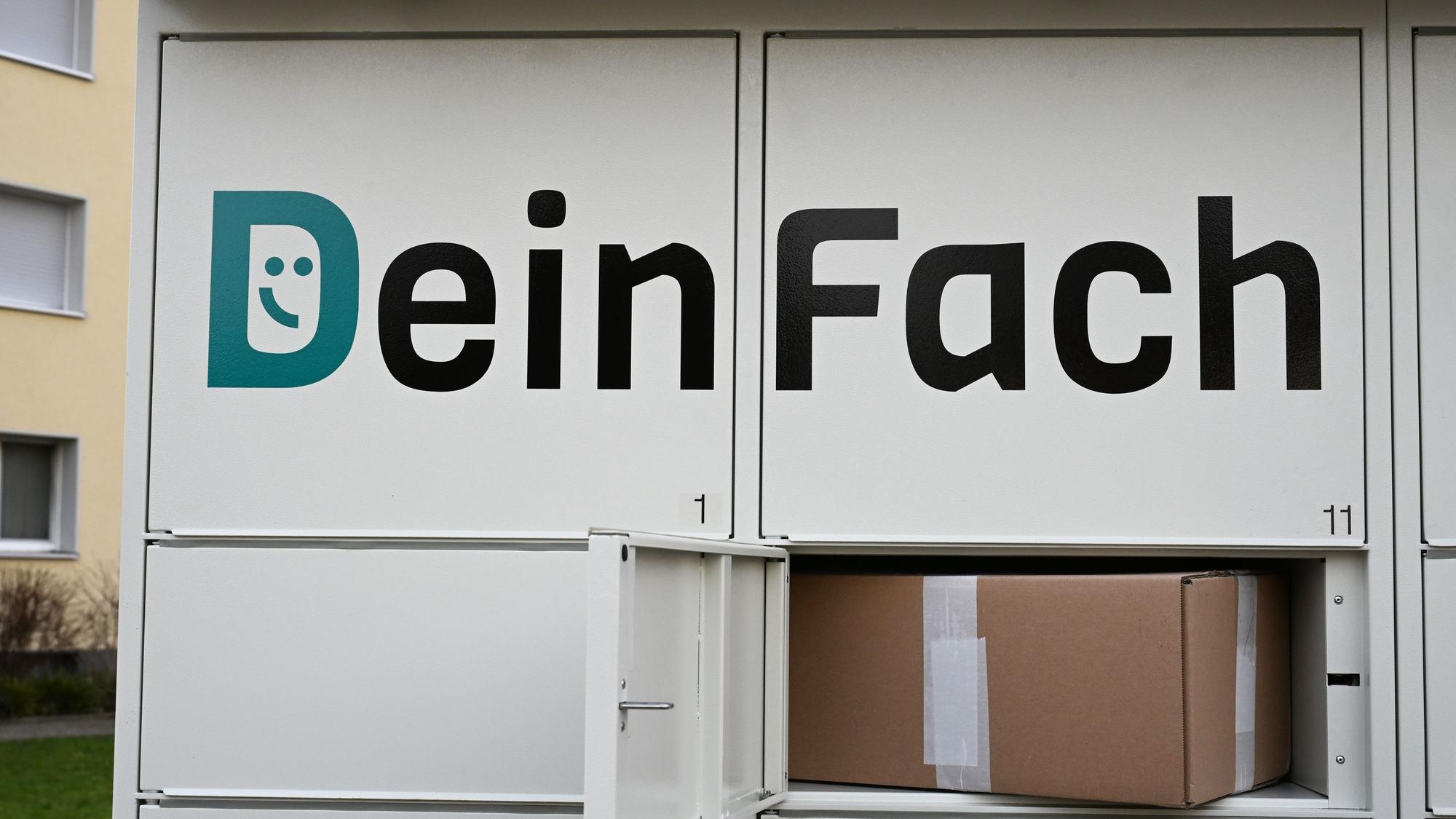 Das Logo der DHL-Tochter DeinFach steht auf einem Paketautomaten der Firma, in einer geöffneten Box liegt ein Paket (gestellte Szene).
