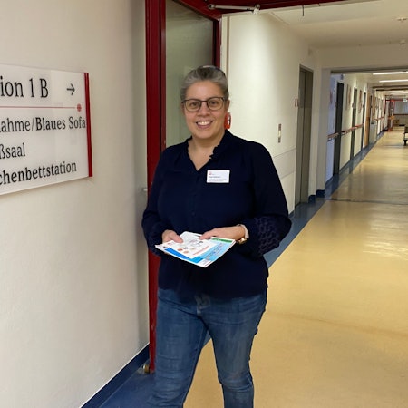 Lotsin Birgit Hellmann läuft den Flur der Wochenbettstation im Marien-Hospital Euskirchen entlang. In den Händen hält sie Infomaterial.