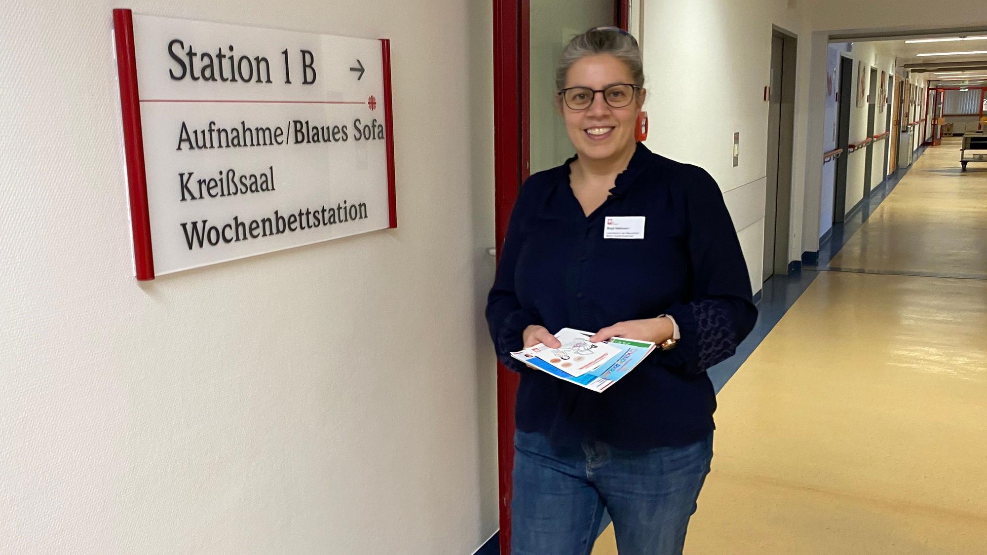 Lotsin Birgit Hellmann läuft den Flur der Wochenbettstation im Marien-Hospital Euskirchen entlang. In den Händen hält sie Infomaterial.