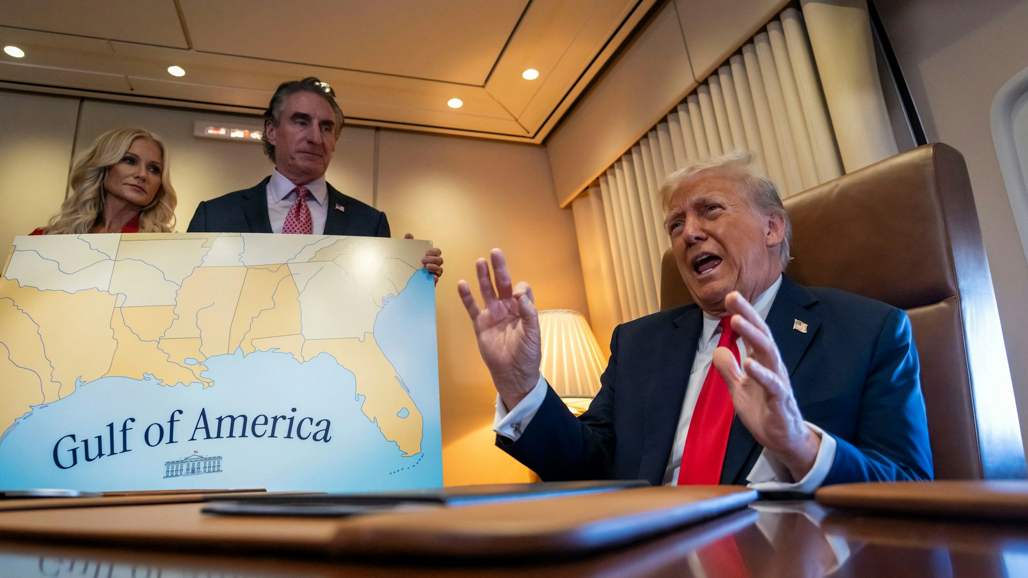 Donald Trump (r.) spricht zu Reportern in Begleitung von Innenminister Doug Burgum (M.) und Burgums Ehefrau Kathryn Burgum an Bord der Air Force One auf dem Flug von West Palm Beach, Florida, nach New Orleans.