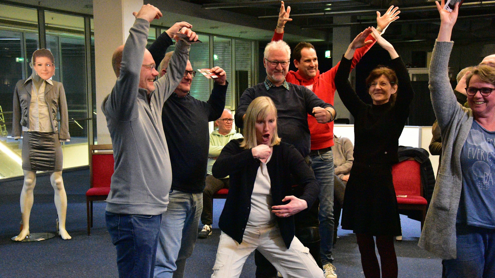 Vier Männer und drei Frauen gestikulieren.