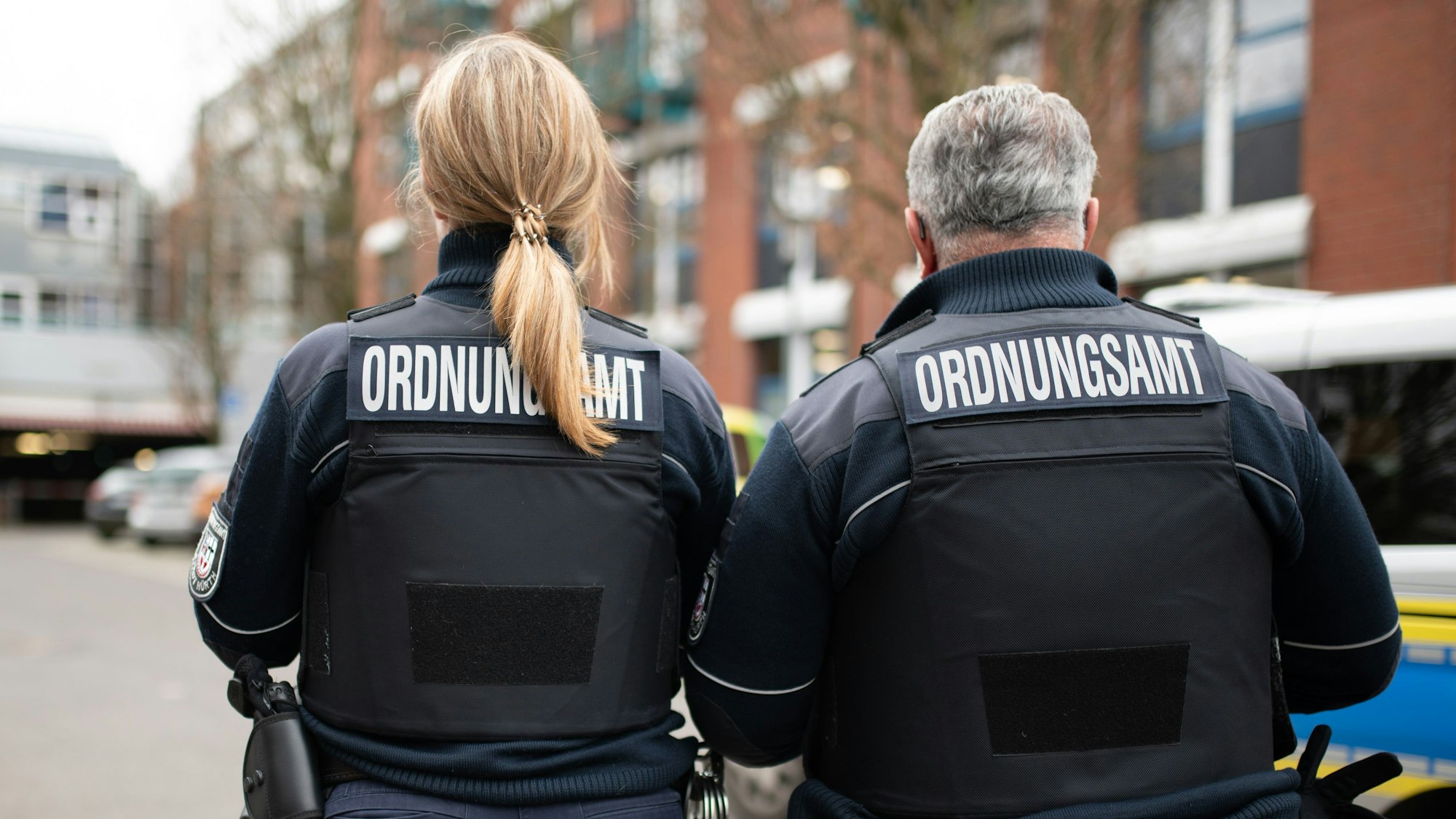 Das Foto zeigt zwei Beschäftigte des Kommunalen Ordnungsdienst mit der Aufschrift „Ordnungsamt“ hinten auf der Jacke.