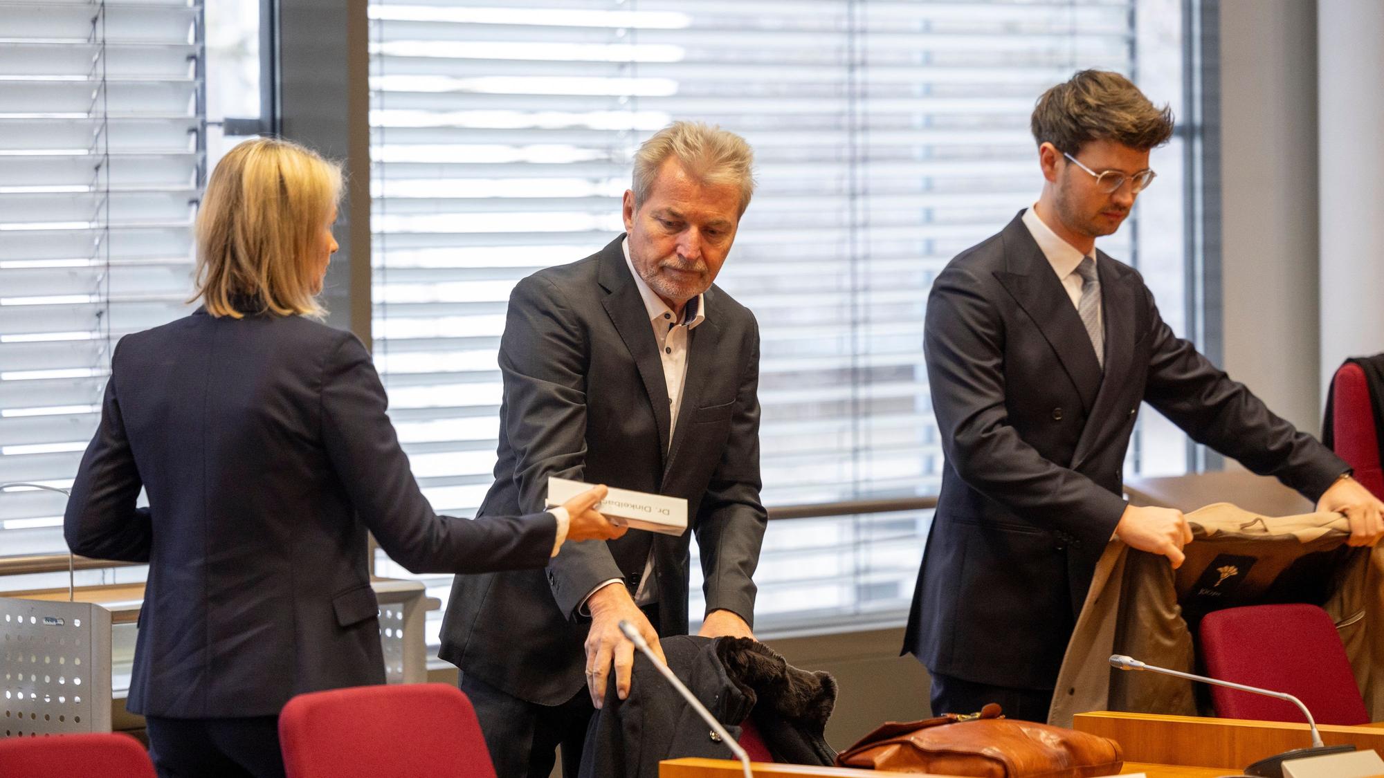 12.02.2025, Nordrhein-Westfalen, Bonn: Der angeklagte Kinder- und Jugendpsychiater Michael Winterhoff (M) steht neben seinen Anwälten Kerstin Stirner (l) und Markus Dinkelbach (r) im Gerichtssaal.