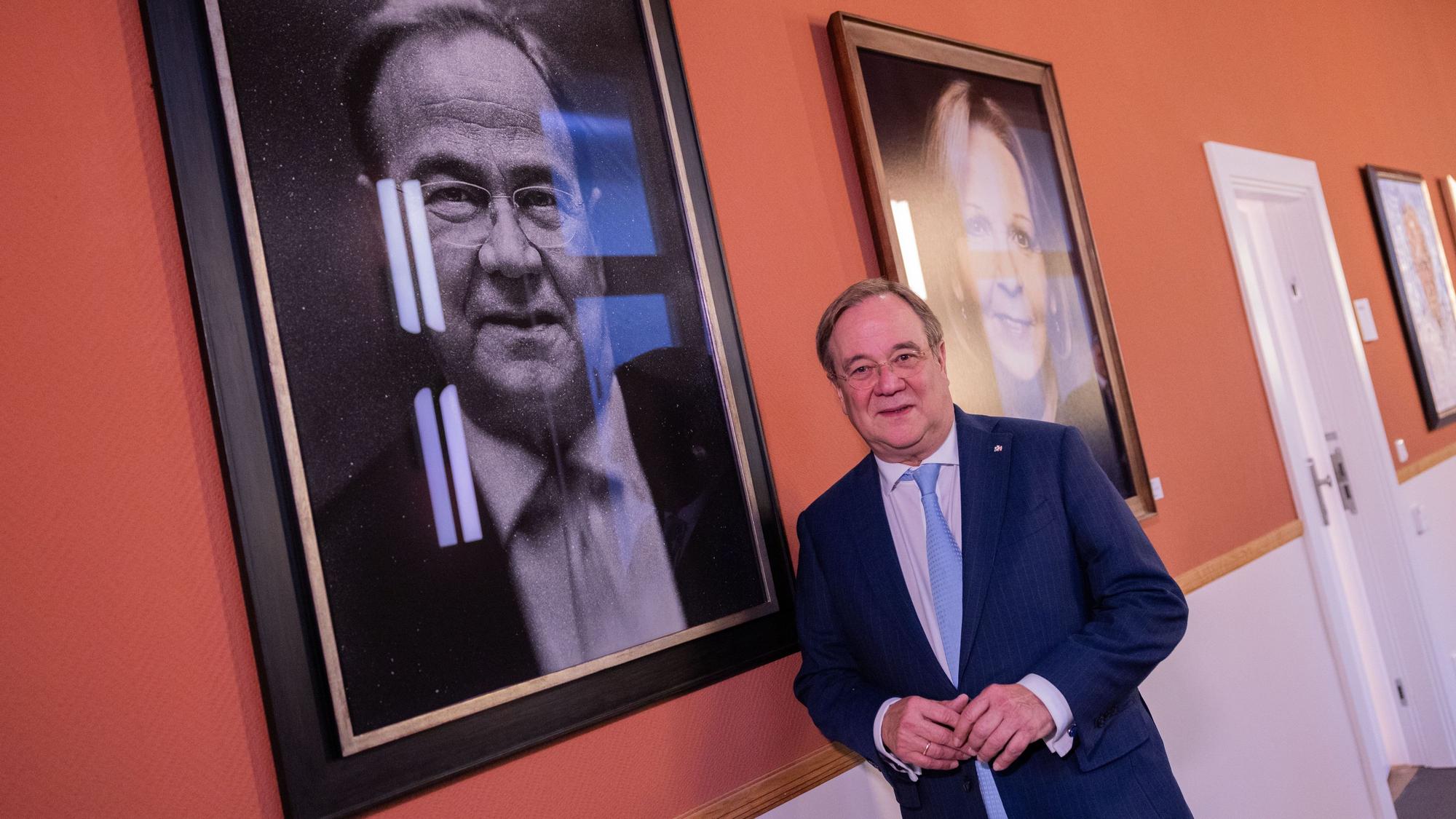 09.12.2024, Nordrhein-Westfalen, Düsseldorf: Armin Laschet (CDU), ehemaliger Ministerpräsident, steht nach der feierlichen Enthüllung seines Porträts in der Ahnengalerie neben dem Werk. Das Porträt hat der Jazz-Trompeter und Fotograf Brönner geschaffen. Foto: Rolf Vennenbernd/dpa - ACHTUNG: Nur zur redaktionellen Verwendung im Zusammenhang mit der aktuellen Berichterstattung und nur mit vollständiger Nennung des vorstehenden Credits +++ dpa-Bildfunk +++