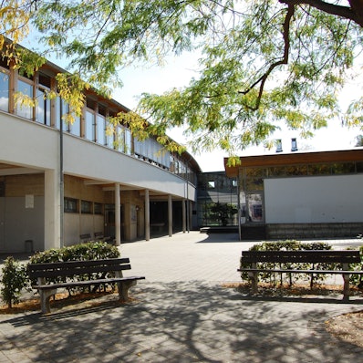 Seitenansicht der Mertener Heinrich-Böll-Schule mit Schulhof.
