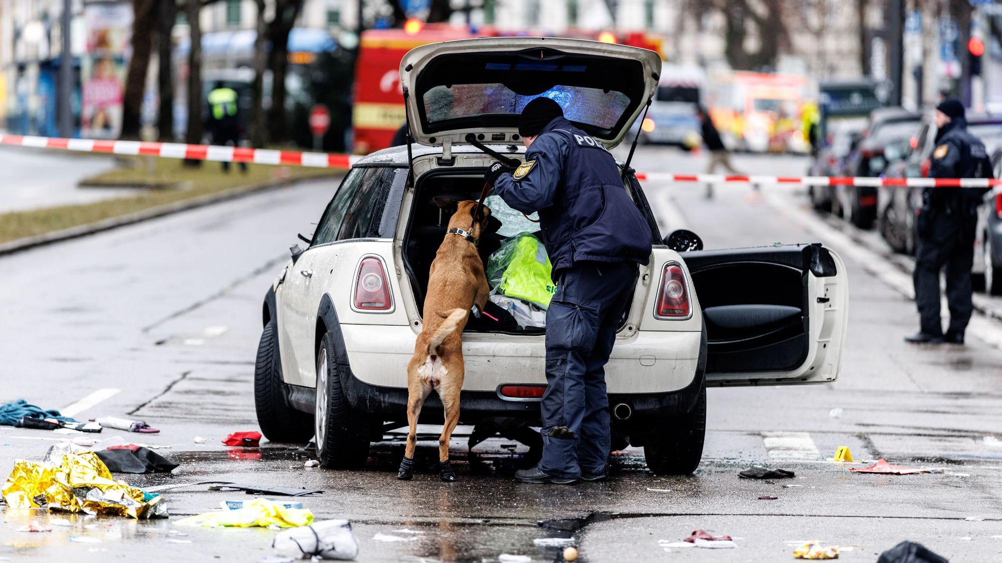 dpatopbilder - 13.02.2025, Bayern, München: Die Polizei untersucht mit einem Spürhund ein Auto unweit des Stiglmaierplatz. In der Münchner Innenstadt ist ein Fahrzeug in eine Menschengruppe gefahren. Foto: Matthias Balk/dpa +++ dpa-Bildfunk +++