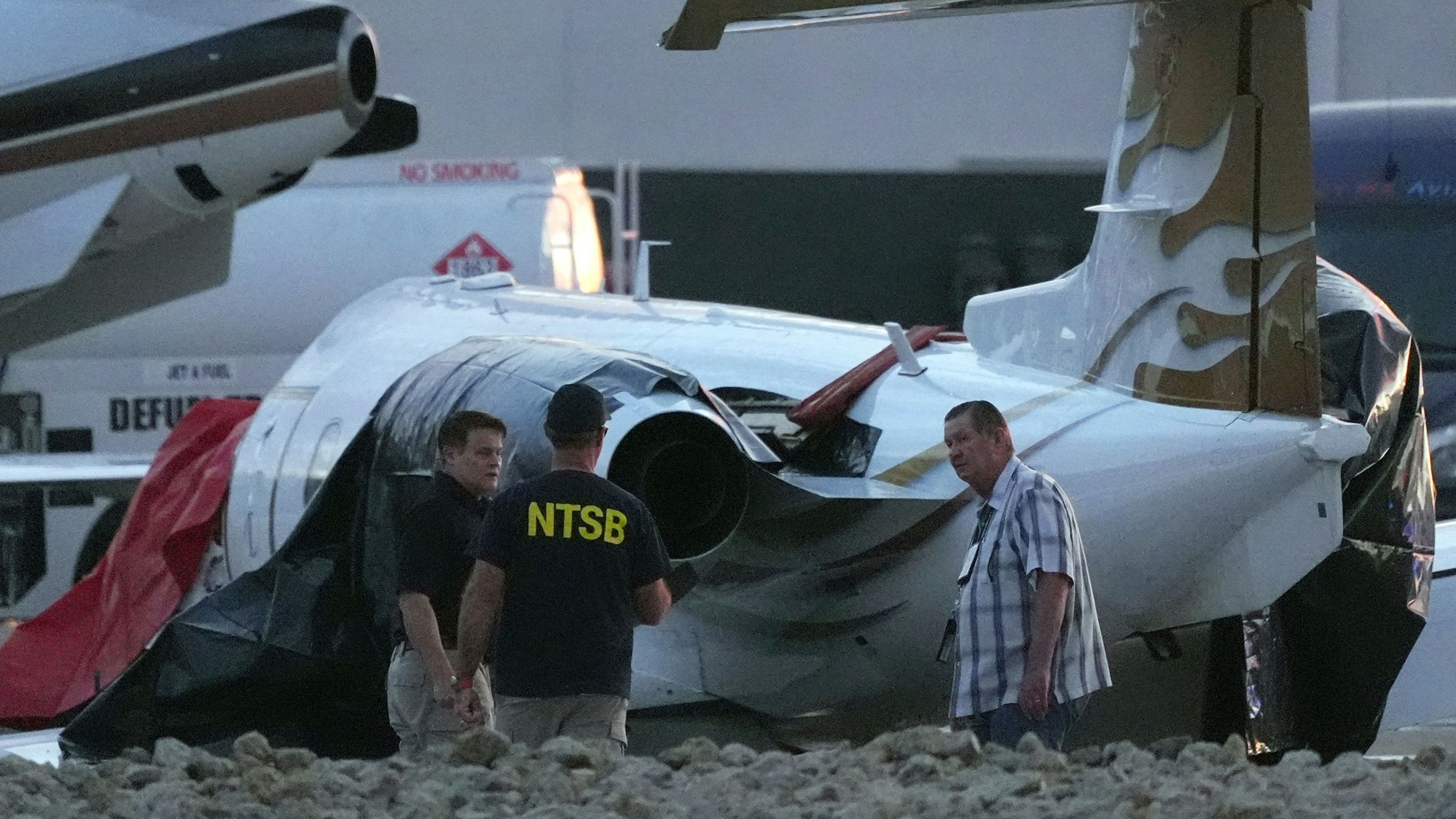 Ermittler untersuchen einen abgestürzten Learjet auf dem Scottsdale Airport, nachdem er in Scottsdale, Arizona, mit einem geparkten Flugzeug kollidiert war.
