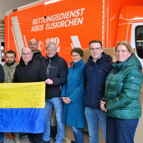 Oleksandr Popov und andere haben sich zu einem Foto aufgestellt. Sie halten eine Landesflagge der Ukraine ins Bild.