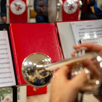 Auf einem Notenständer steht ein Notenblatt mit der Aufschrift „Marsch der Großen Allgemeinen“.