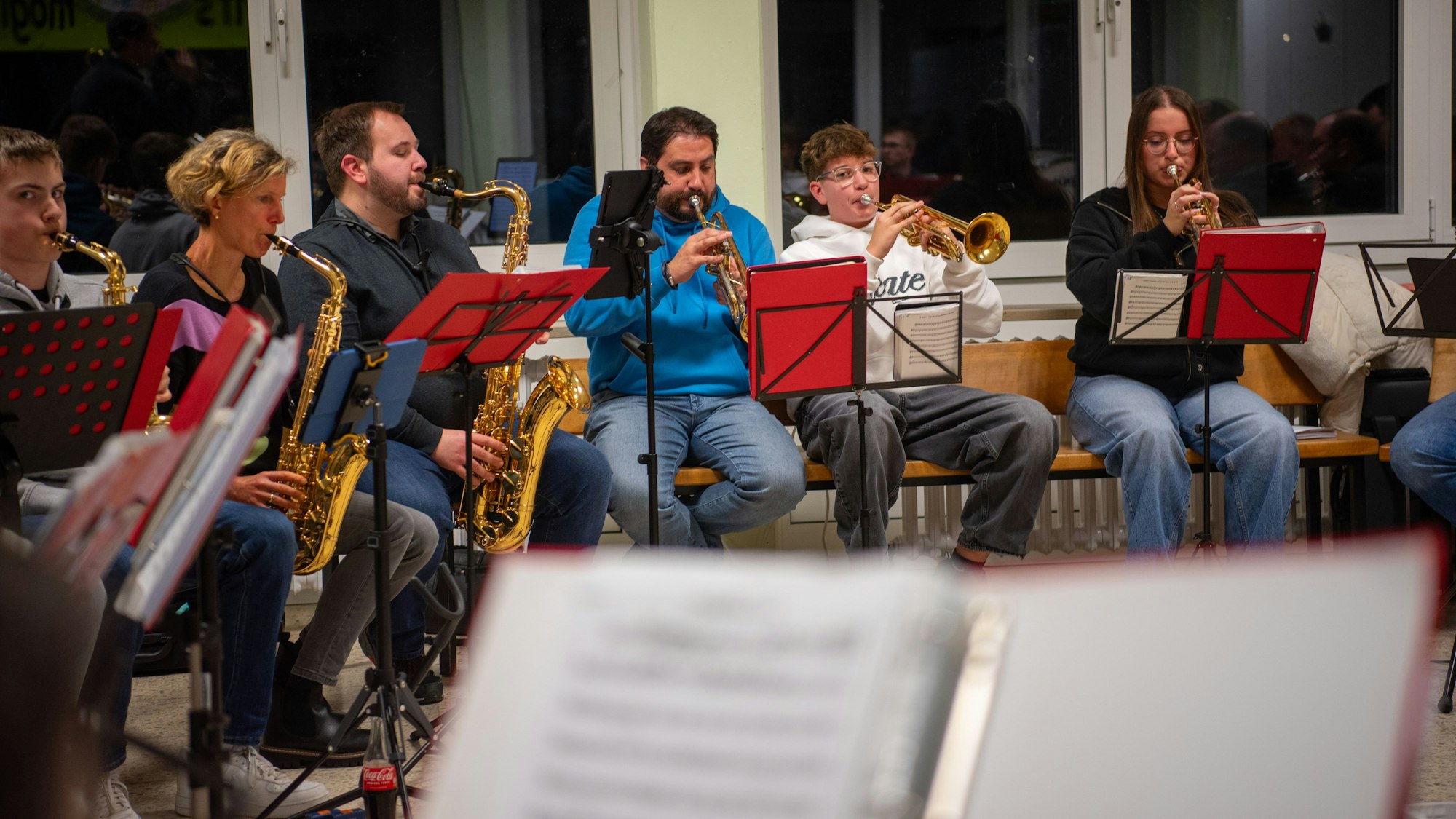 Eine Gruppe von Musikerinnen  und Musikern sitzt im Halbkreis und spielt.