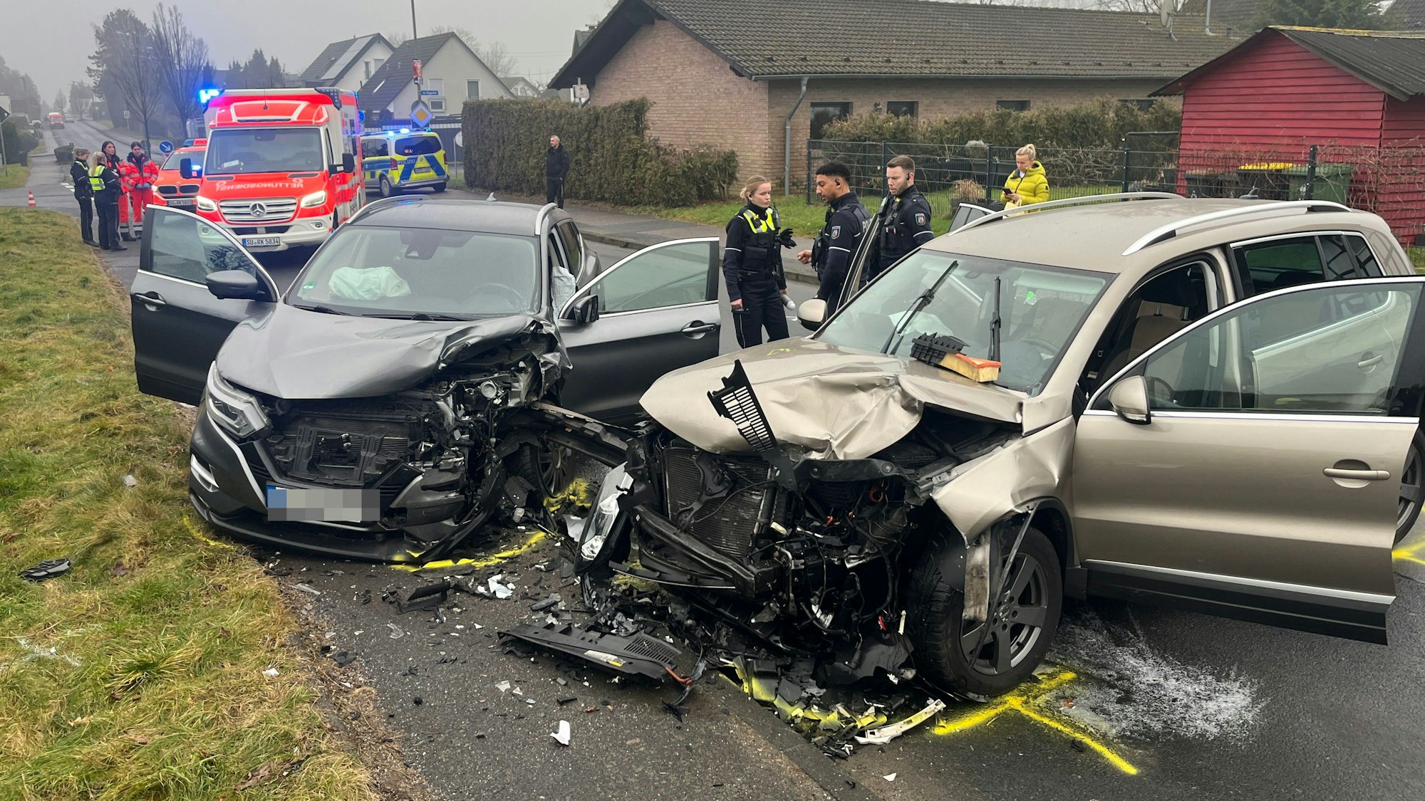 Zwei schwer beschädigte Autos stehen nach einem Unfall am Straßenrand.