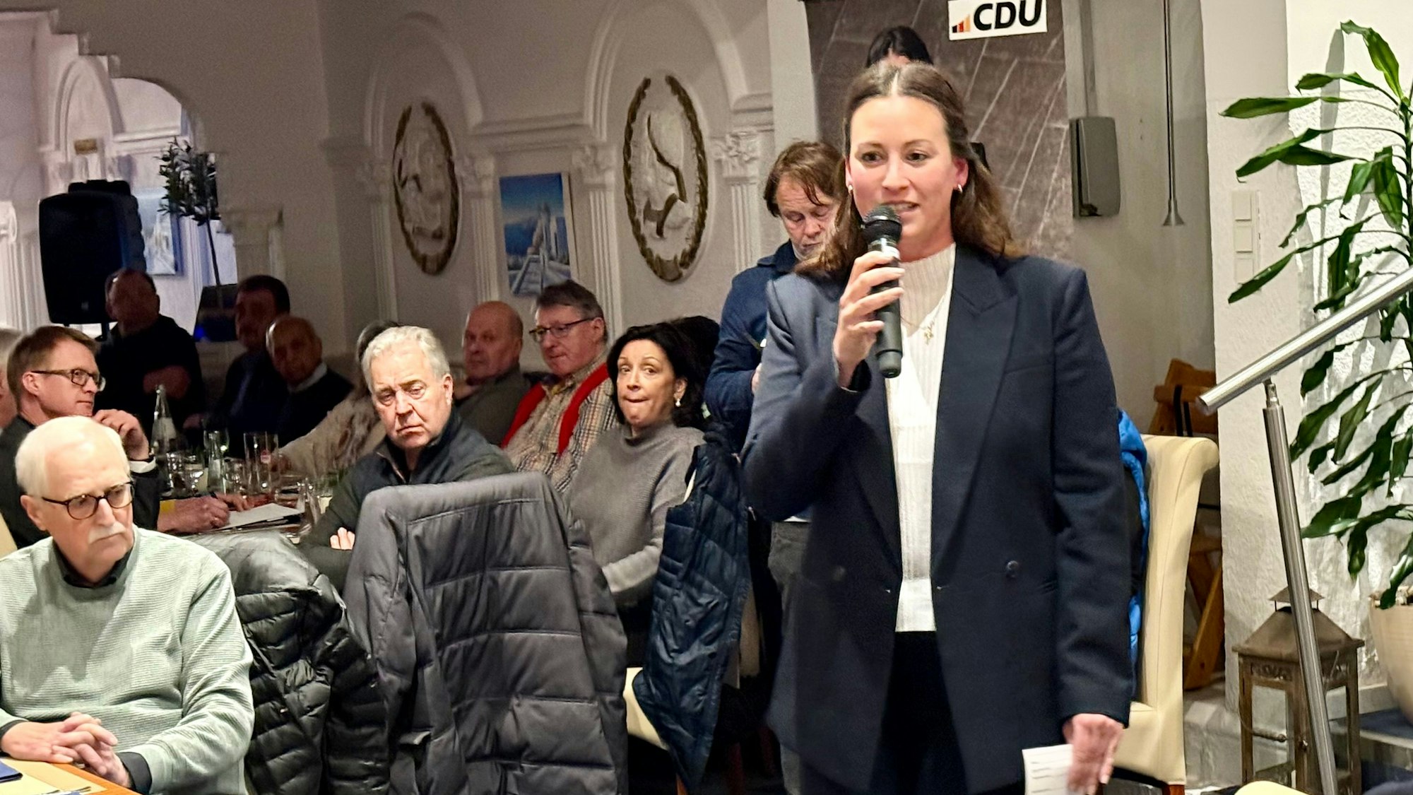 Caroline Bosbach mit Mikrofon im Burscheider Restaurant „Korfu“