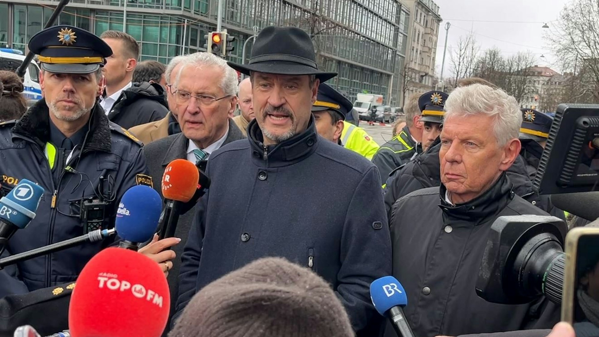 Bayerns Ministerpräsident Markus Söder (CSU, M), Innenminister Joachim Herrmann (CSU, 2.v.l.) und Dieter Reiter (SPD, r) geben am Einsatzort ein Statement, nachdem in der Münchner Innenstadt ein Fahrzeug in eine Menschengruppe gefahren ist.