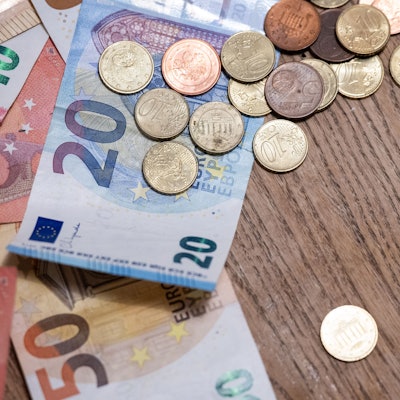 Geldscheine und Münzen liegen auf einem Tisch.