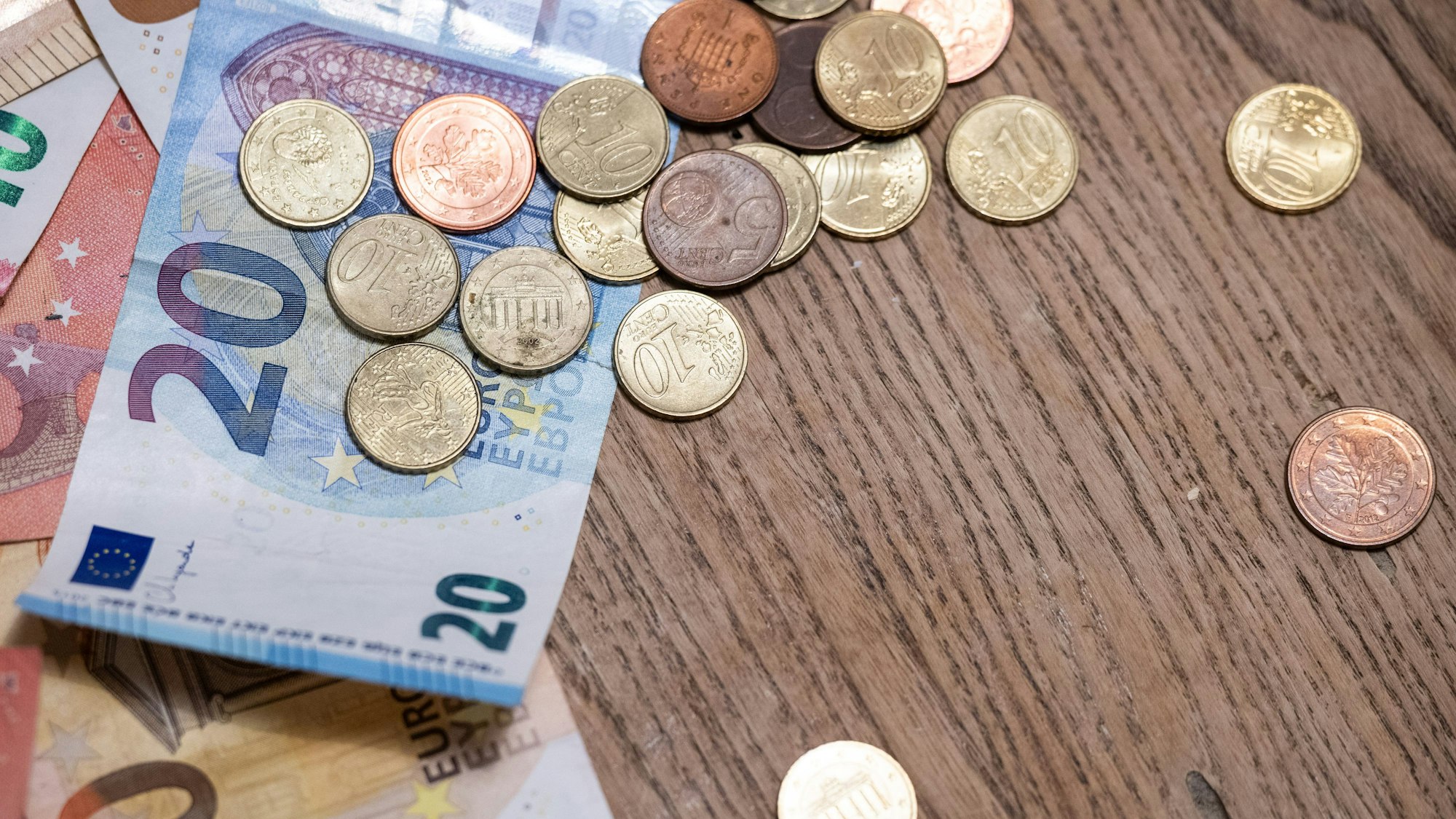 Geldscheine und Münzen liegen auf einem Tisch.