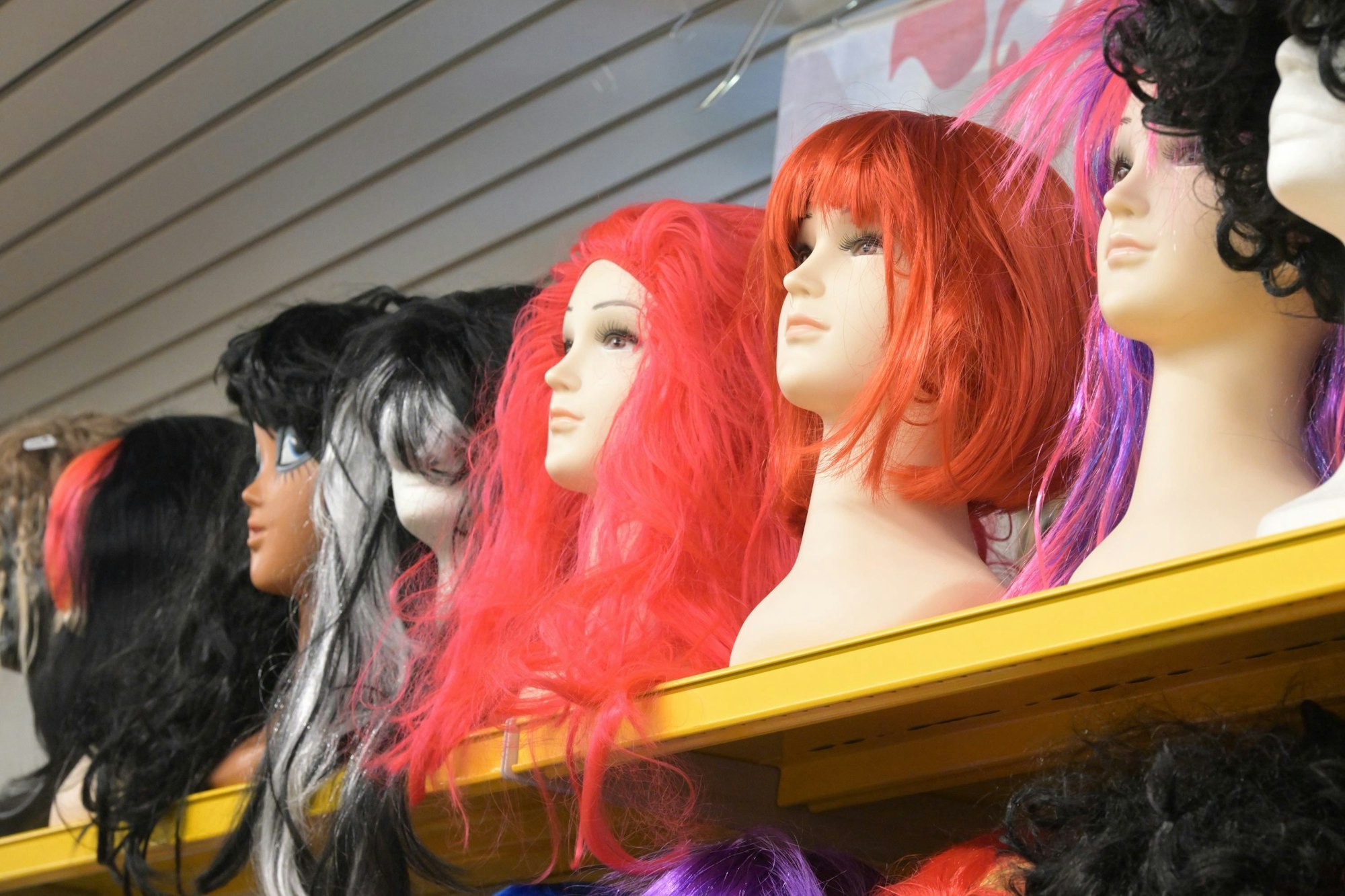 Das Foto zeigt Puppen mit Karnevalsperücken