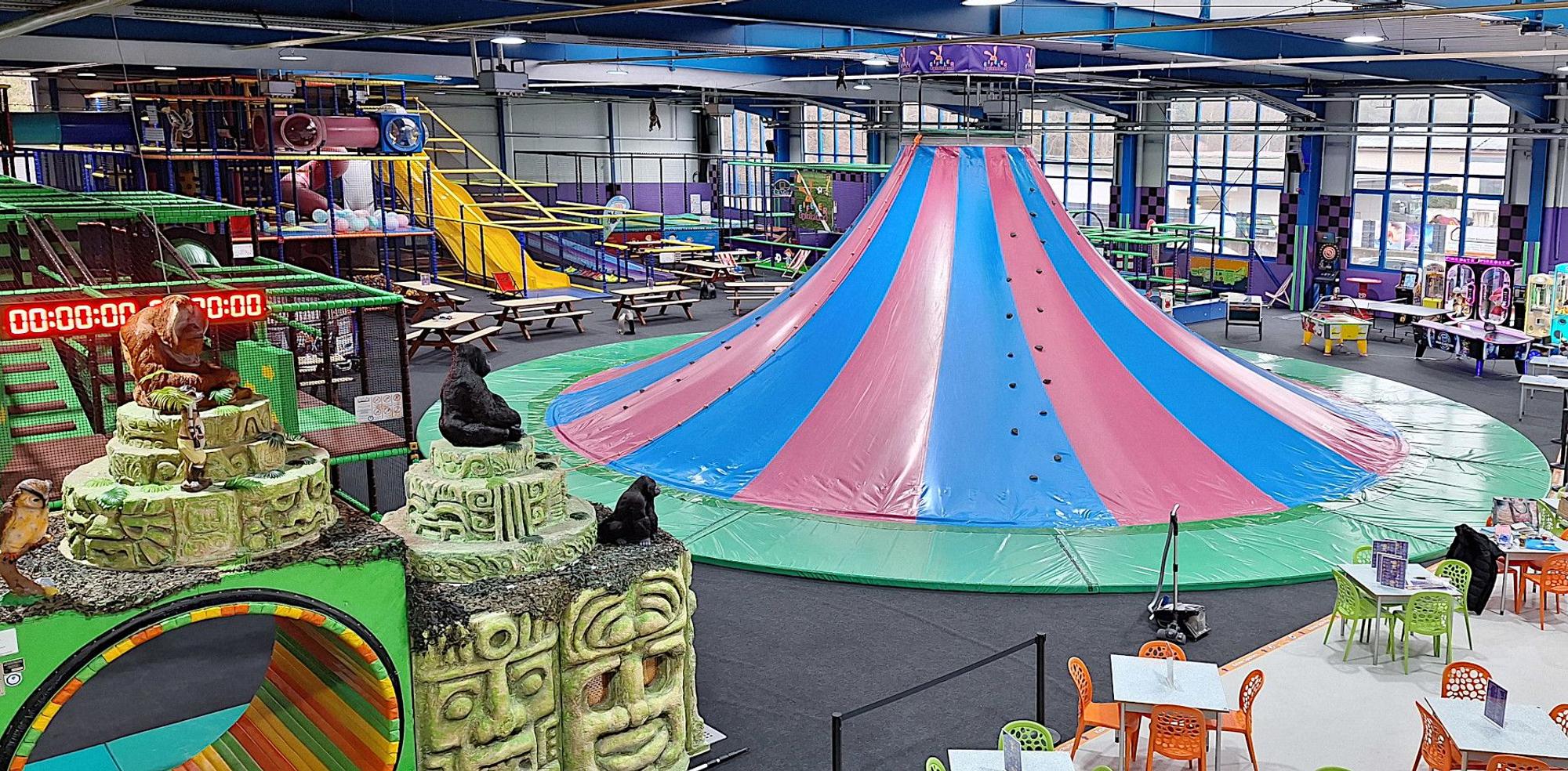 Einem Vulkan ähnelt die rot und blau gestreifte Konstruktion, die in einer Halle des Spielelands in Bad Münstereifel steht und Gelegenheit zum Klettern und Rutschen bietet.