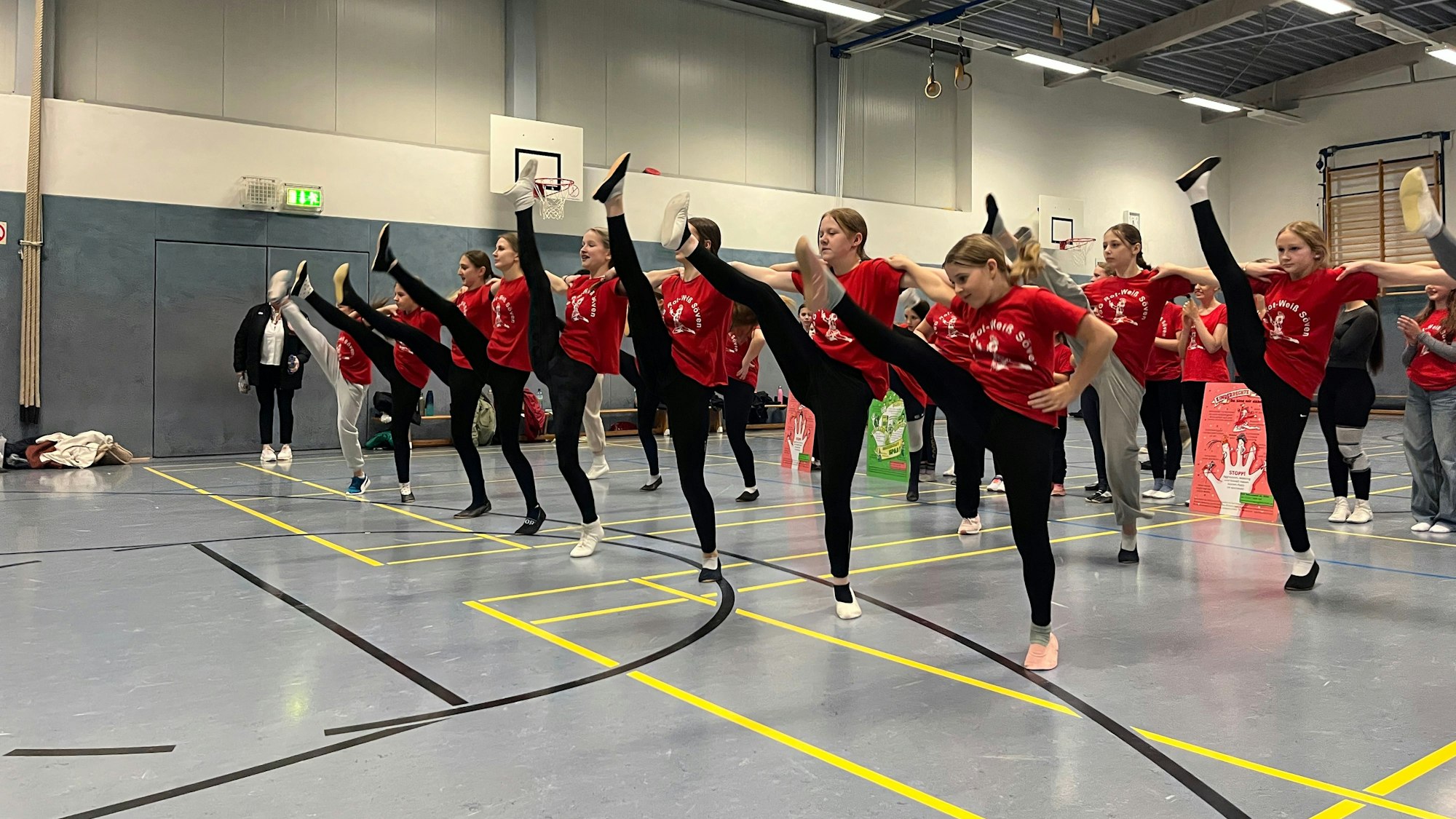 Junge Tänzerinnen werfen beim Training ihre Beine in die Höhe.