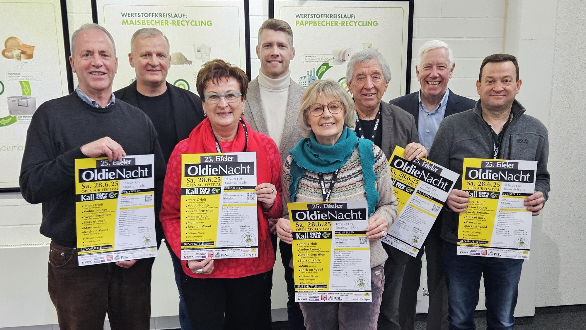 Hermann-Josef Esser, Bernd Born, Dagmar Poth (Hilfsgruppe), Tom Kantelberg; Kathi und Willi Greuel, Bert Kantelberg und Thomas Tampier stehen nebeneinander und präsentieren Plakate von der Oldie-Nacht.