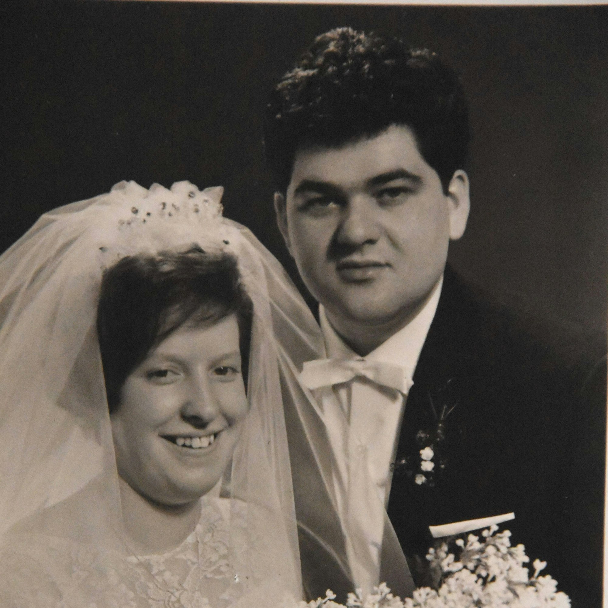 Eine Ehepaar bei seiner Hochzeit in schwarz-weiß.