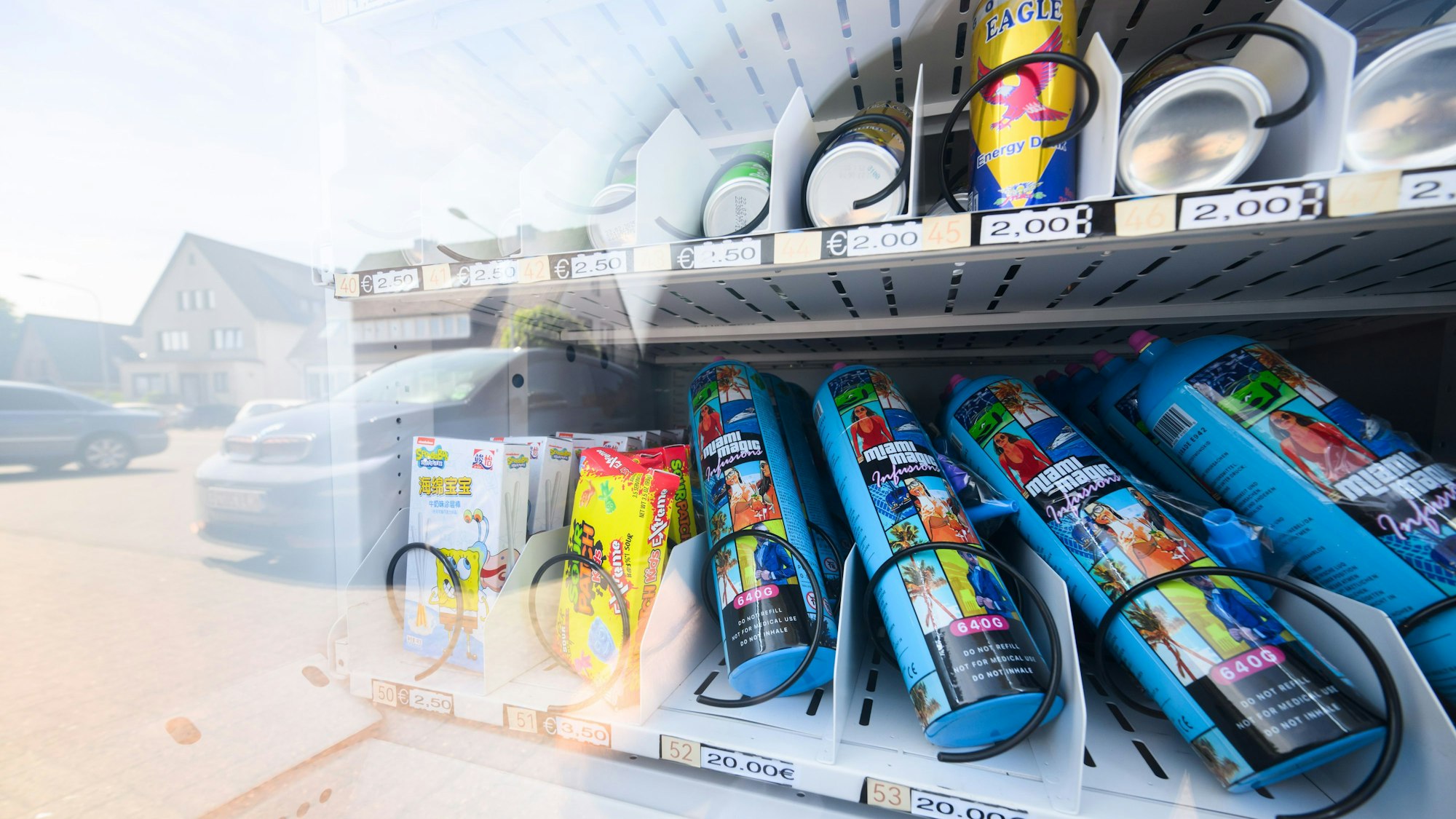 Ein Warenautomat, unter anderem mit Lachgasflaschen bestückt, steht vor einem Ladengeschäft. (Archivbild)