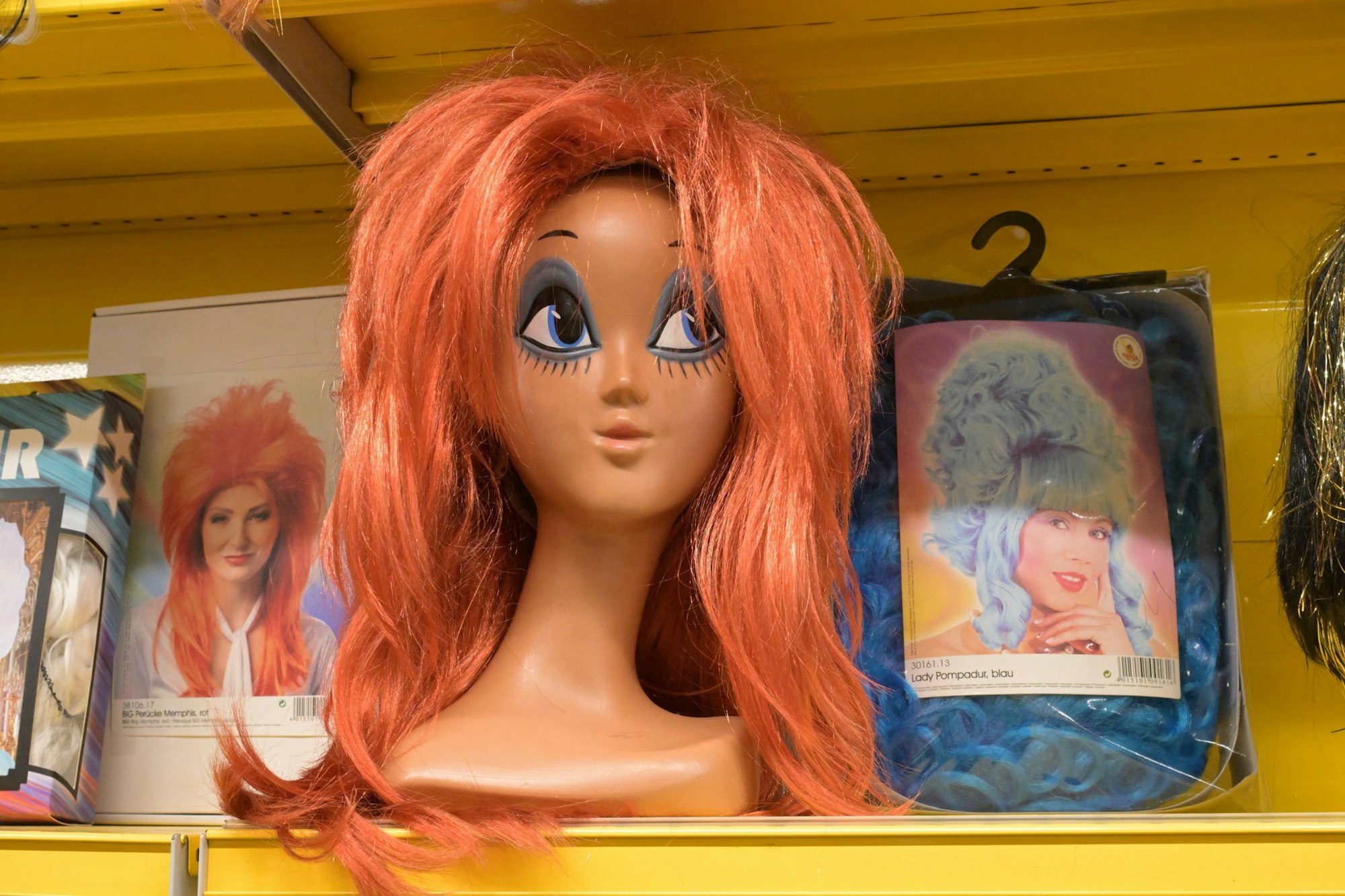 Das Foto zeigt eine Puppe mit roter Perücke.