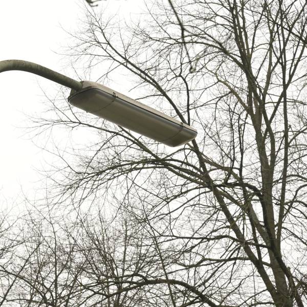 An einer Straße steht eine Straßenlampe in Bogenform.