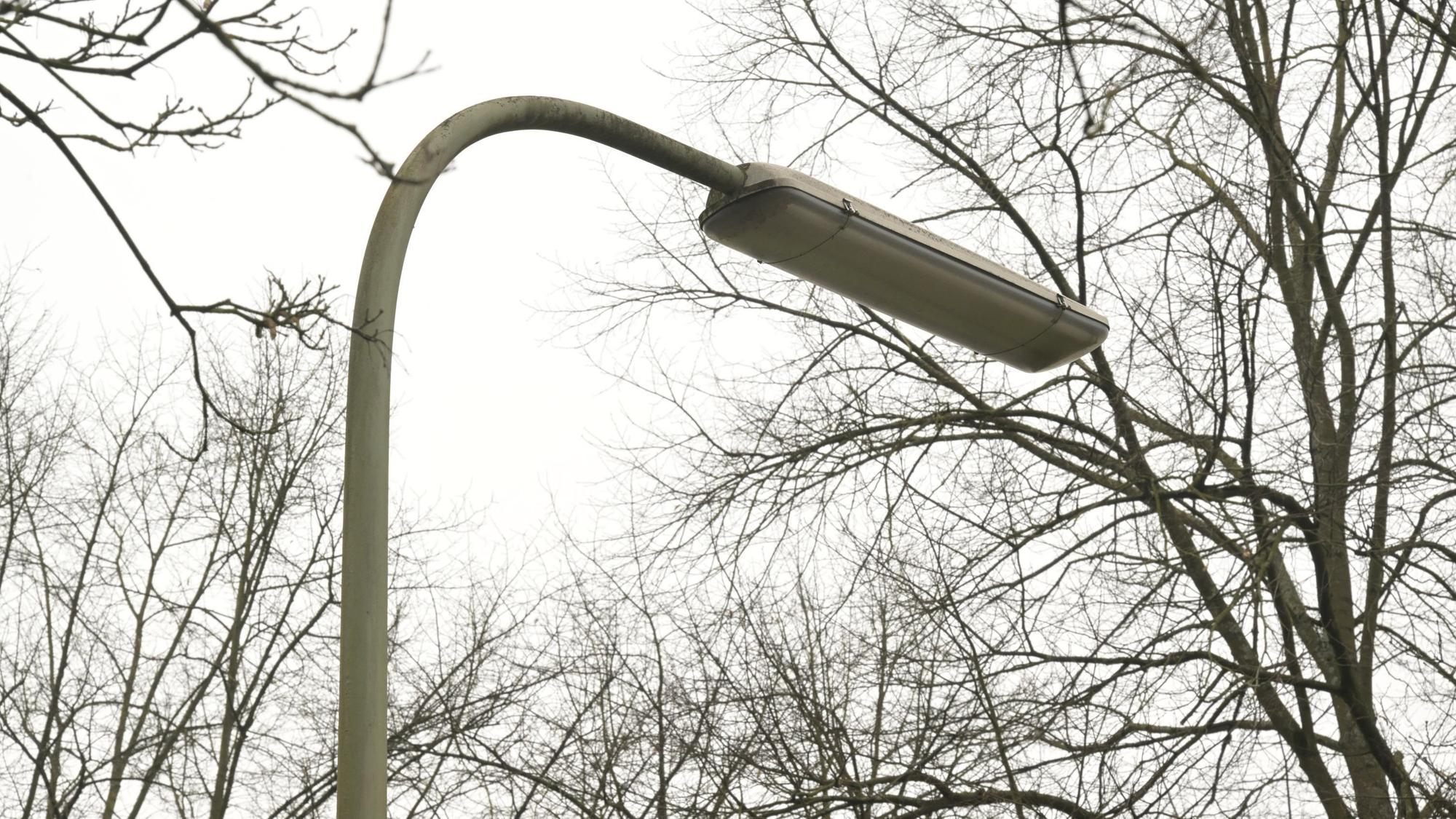 An einer Straße steht eine Straßenlampe in Bogenform.