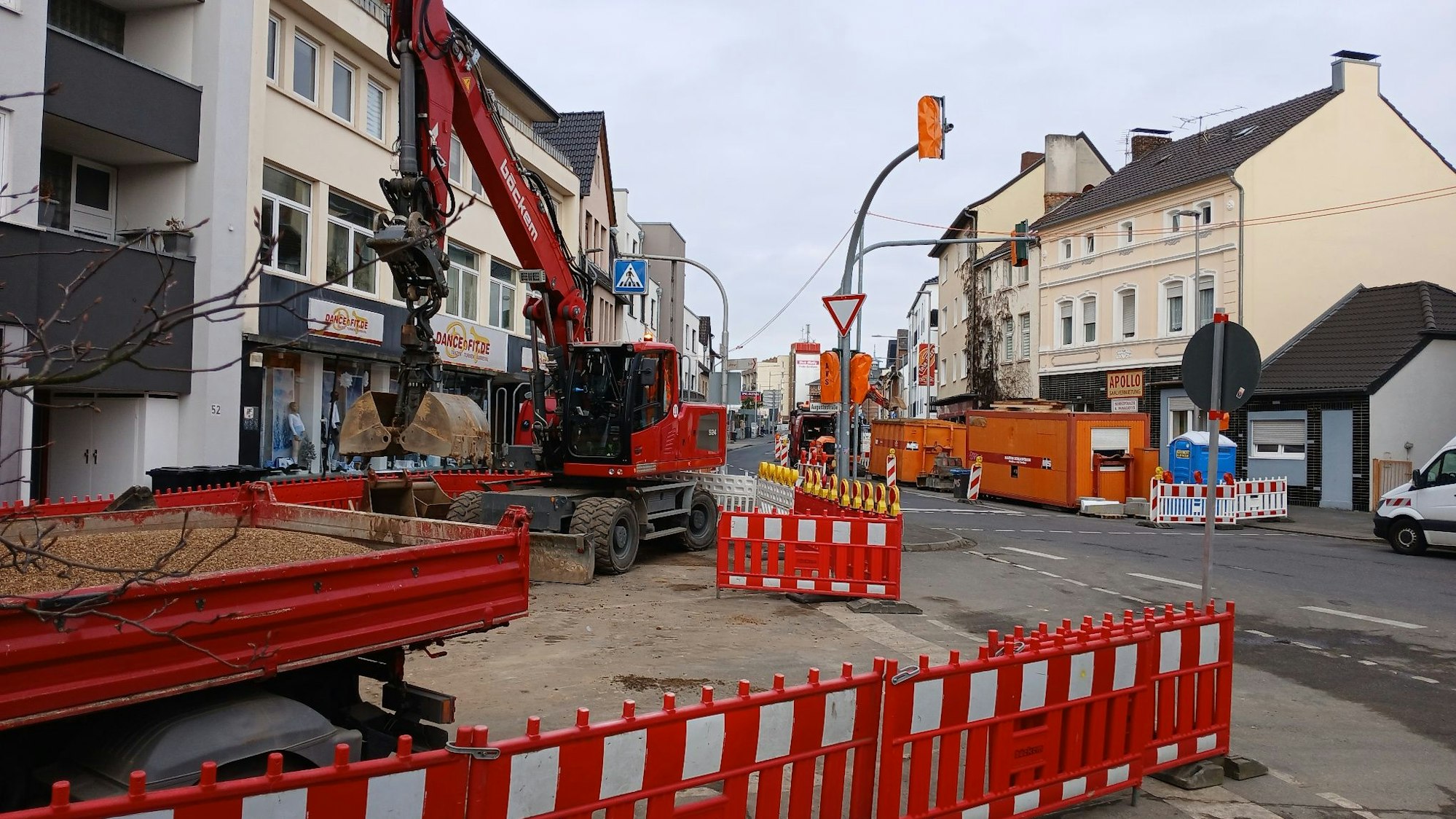 Eine Straßenbaustelle mit Absperrungen und Bagger.