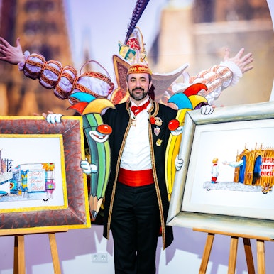 Der neue Zugleiter Marc Michelske mit zwei Zeichnungen der Persiflagewagen.