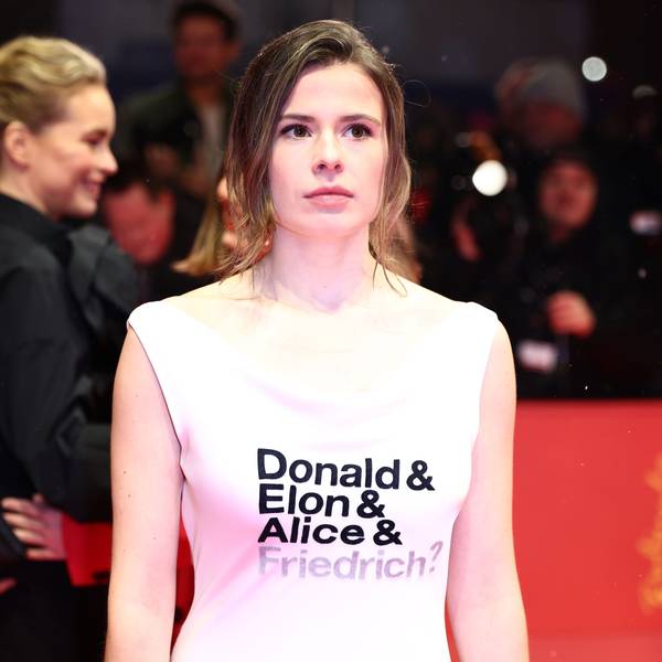 Luisa Neubauer, Aktivistin, steht am Eröffnungsabend der Berlinale auf dem Roten Teppich und trägt ein Kleid mit der Aufschrift „Donald & Elon & Alice & Friedrich?“.