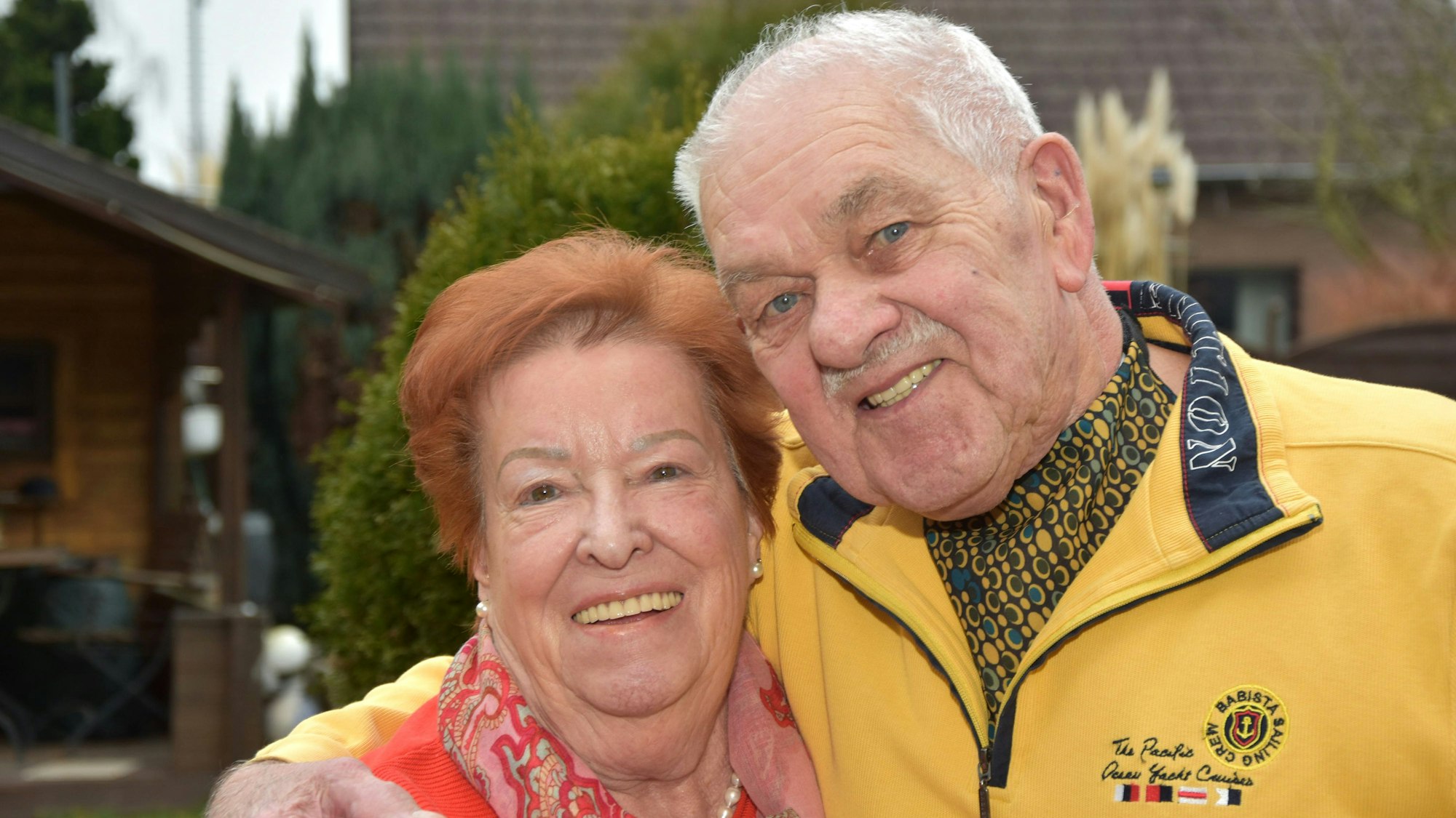 Ein älteres Ehepaar hält sich in den Armen und lächelt.