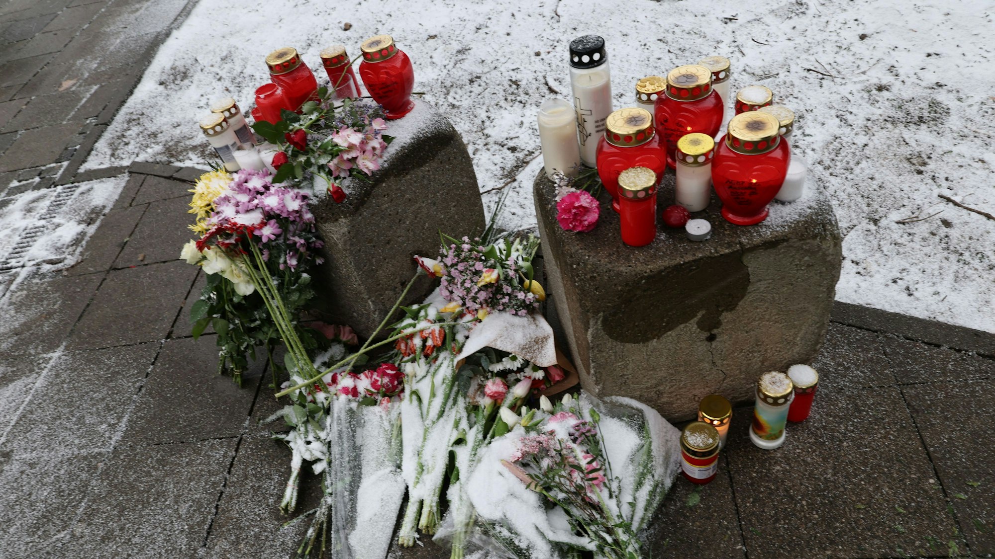 Blumen und Kerzen sind an der Stelle zu sehen, wo am Vortag ein Auto die Menschenmenge gefahren war.