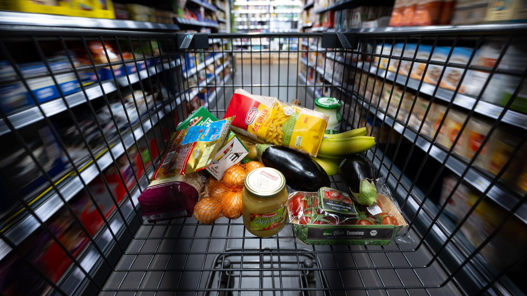 Verschiedene Lebensmittel liegen in einem Supermarkt in einem Einkaufswagen. (Symbolbild)
