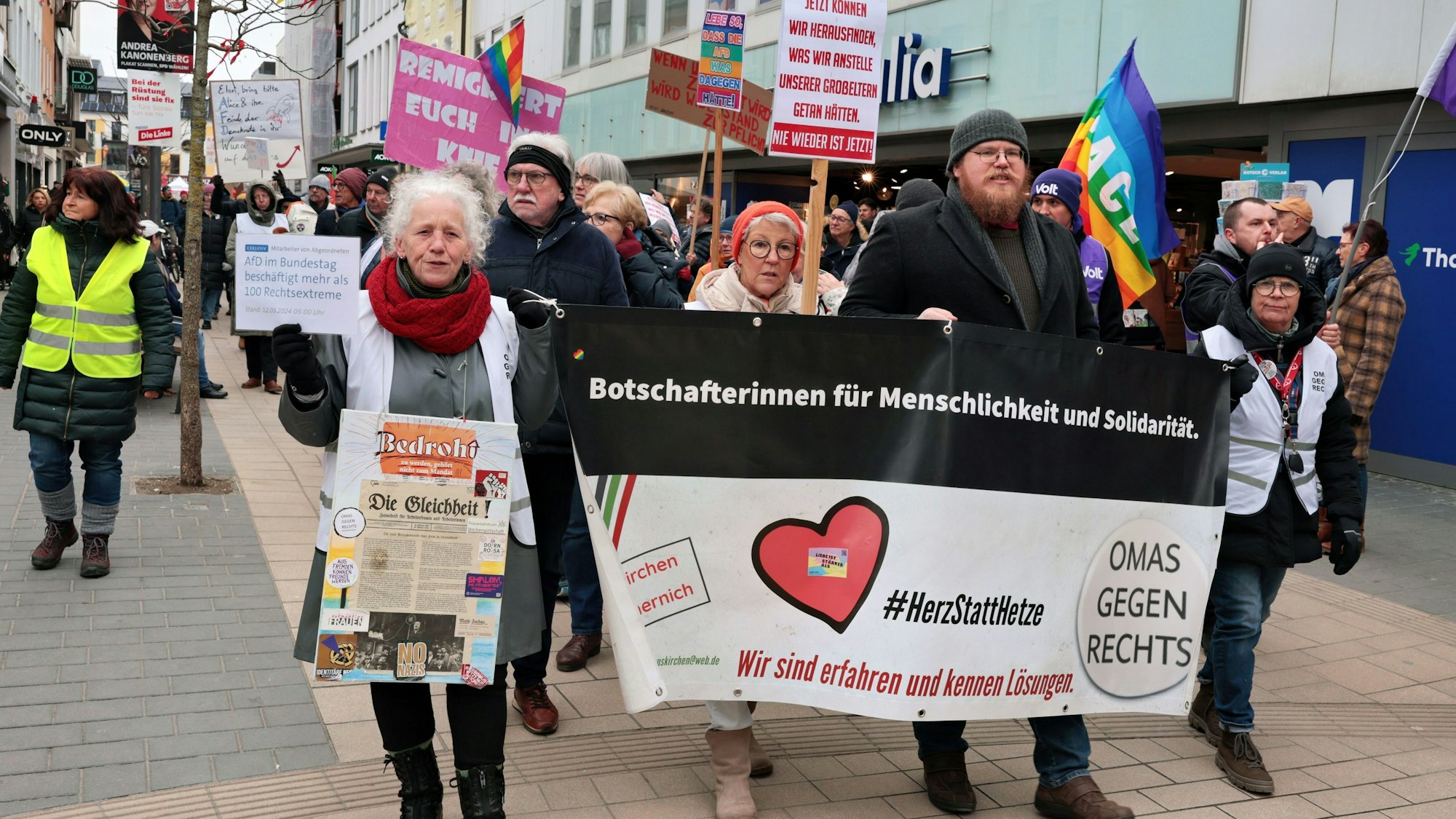 Rund 550 Teilnehmer demonstrierten in Euskirchen für Freiheit und Demokratie. Einige Teilnehmer halten Fahnen hoch oder gehen hinter einem Transparent der Omas gegen Rechts.
