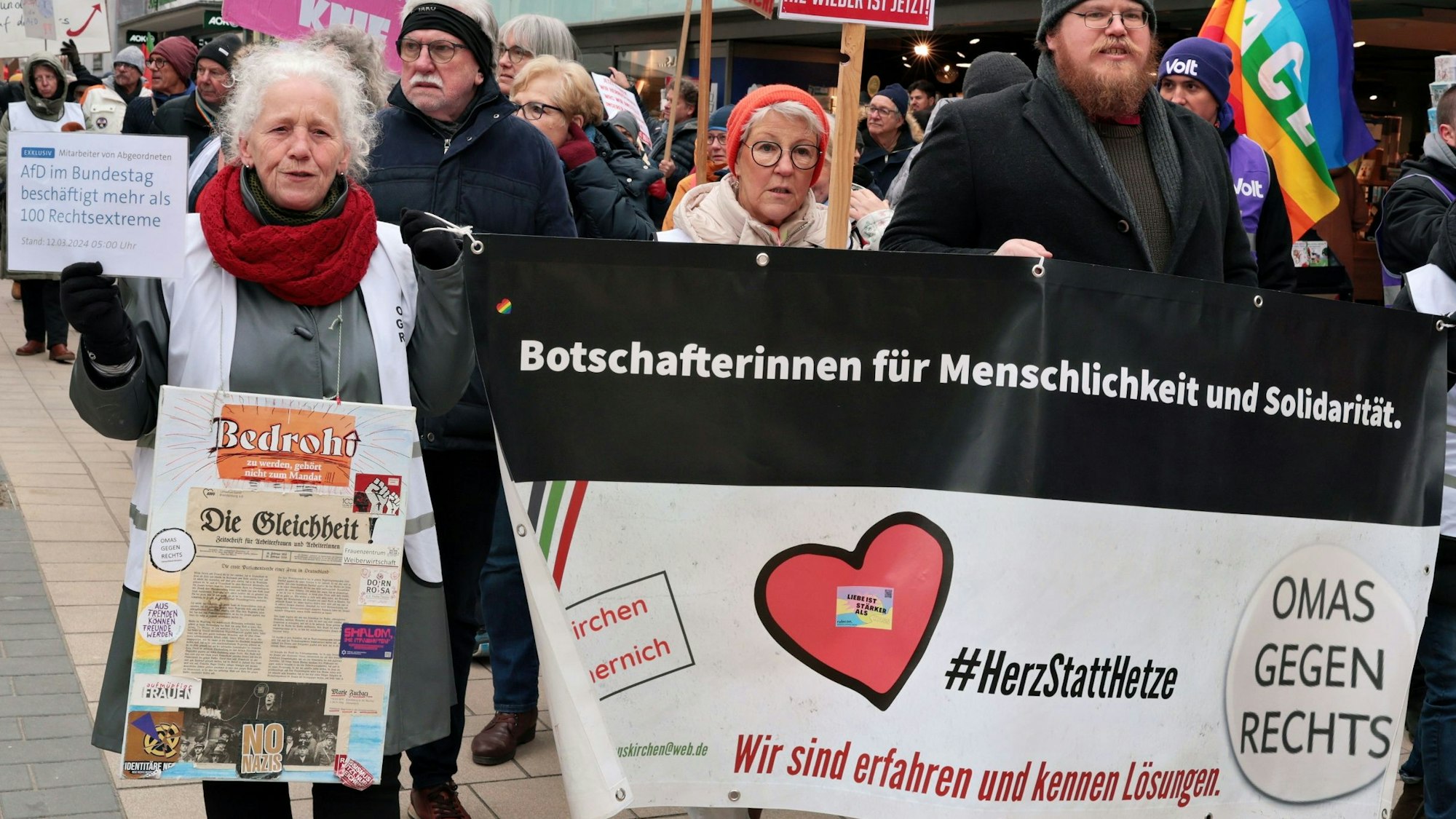 Waltraud Forner an der Spitze einer Demonstration gegen Rechts in Euskirchen neben einem Transparent der Omas gegen Rechts. Sie hält ein Schild mit der Aufschrift „AfD im Bundestag beschäftigt mehr als 100 Rechtsextreme“ hoch.