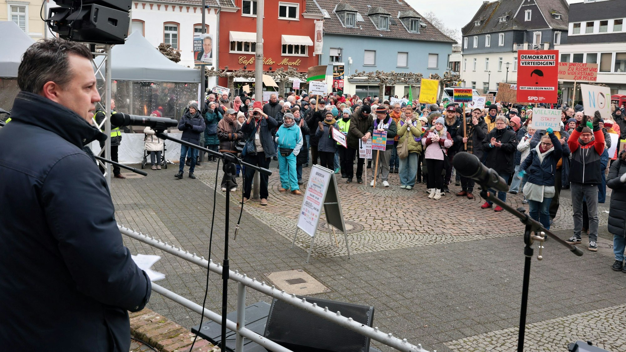 Euskirchens Bürgermeister Sacha Reichelt steht bei einer Kundgebung auf dem Alten Markt in Euskirchen auf einer Bühne, rechts sind die Demonstranten zu sehen.