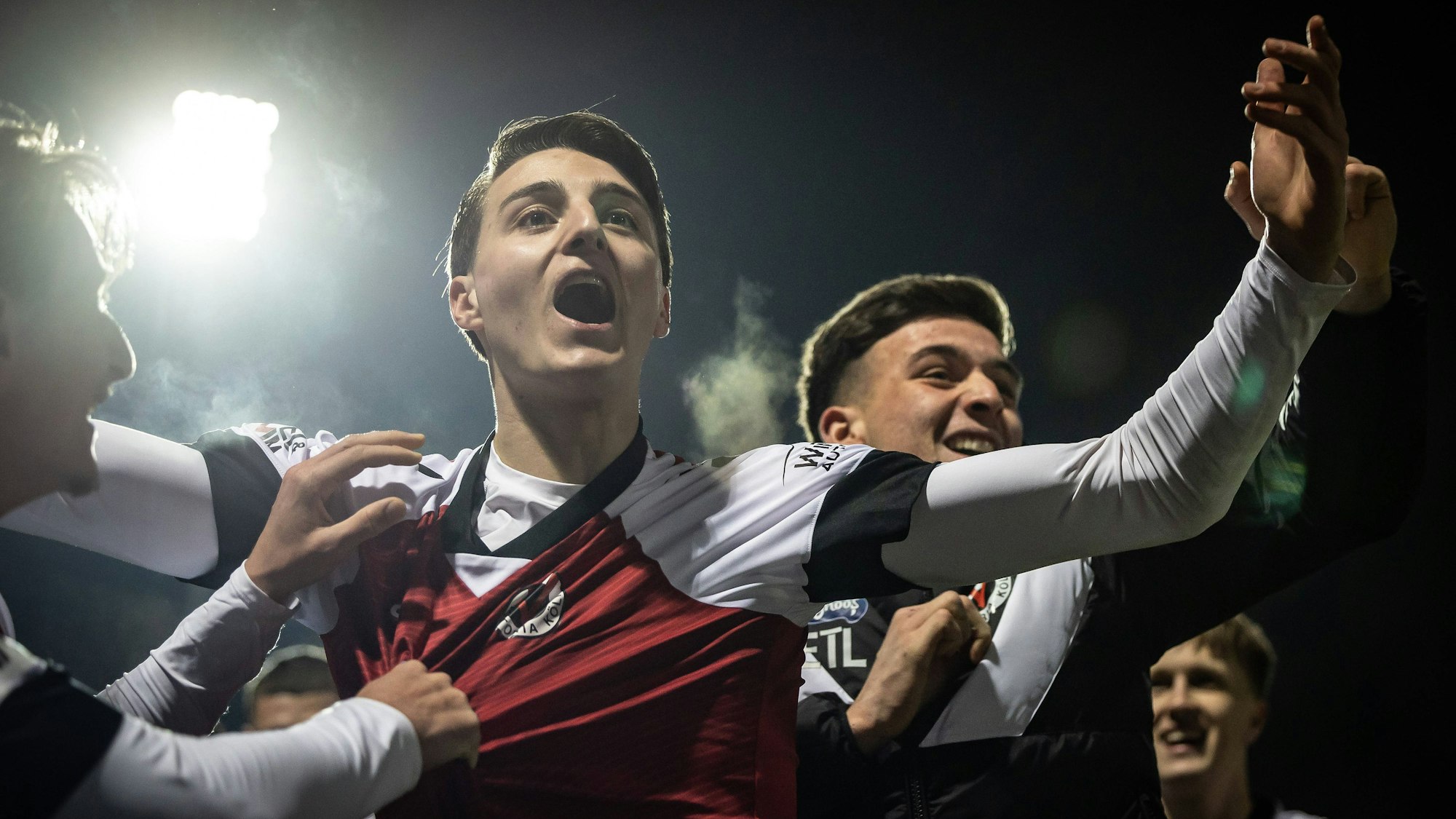 Viktoria Kölns Malek El Mala (M.) und sein Bruder Said (r.) feiern den 3:1-Sieg über Aachen.