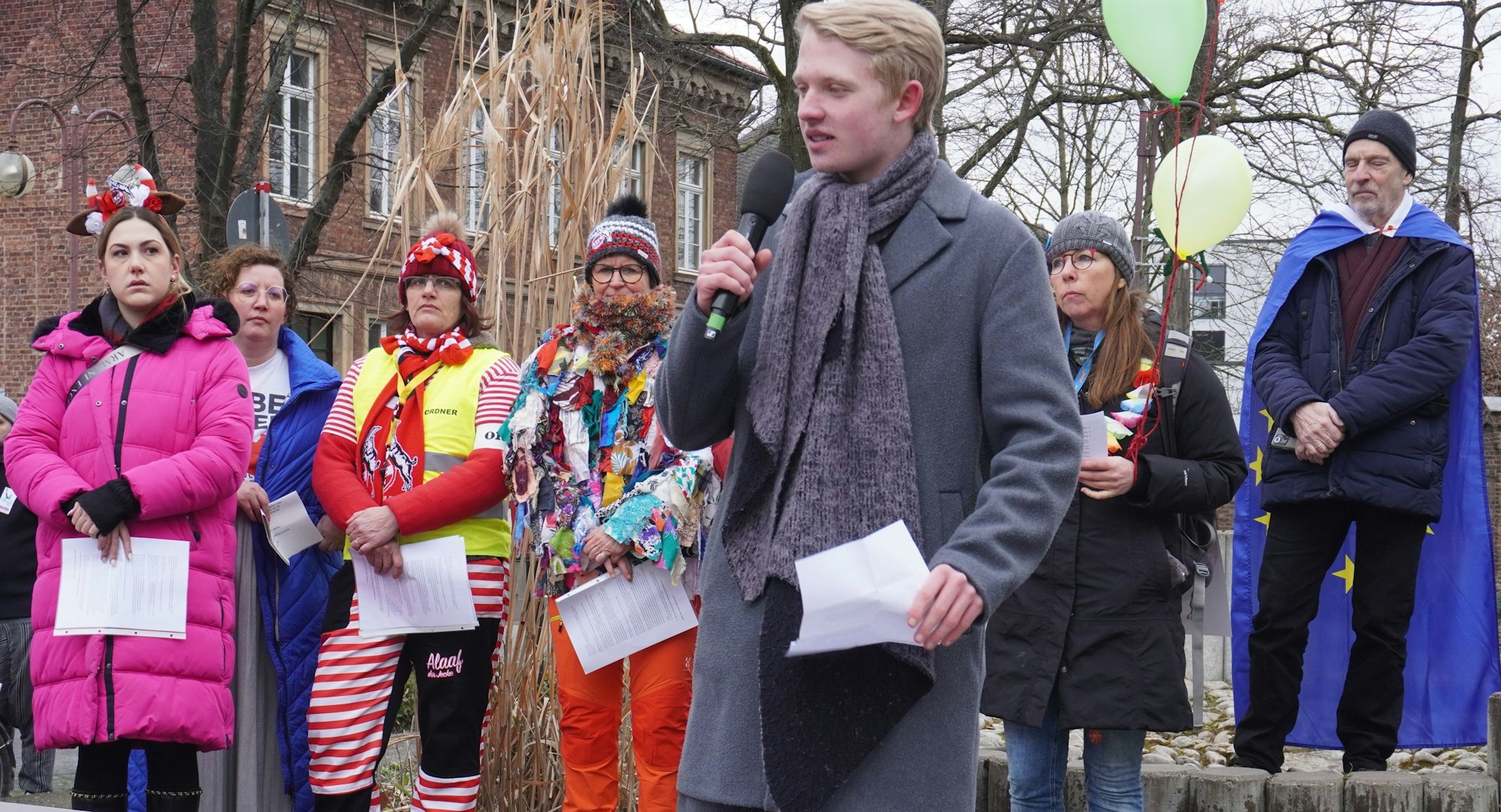 Auf dem Bild sind Teilnehmer der Demonstration und ein Junge an einem Mikrofon zu sehen.