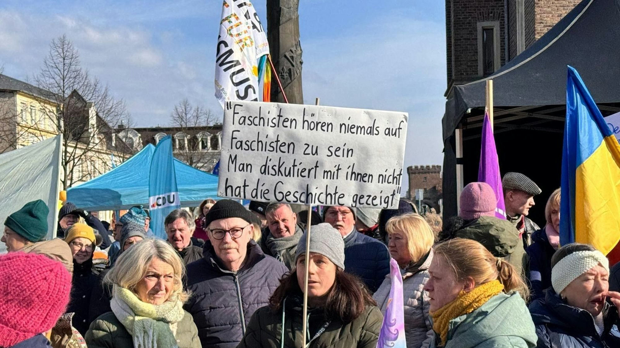 Menschen tragen Fahnen und Plakate.