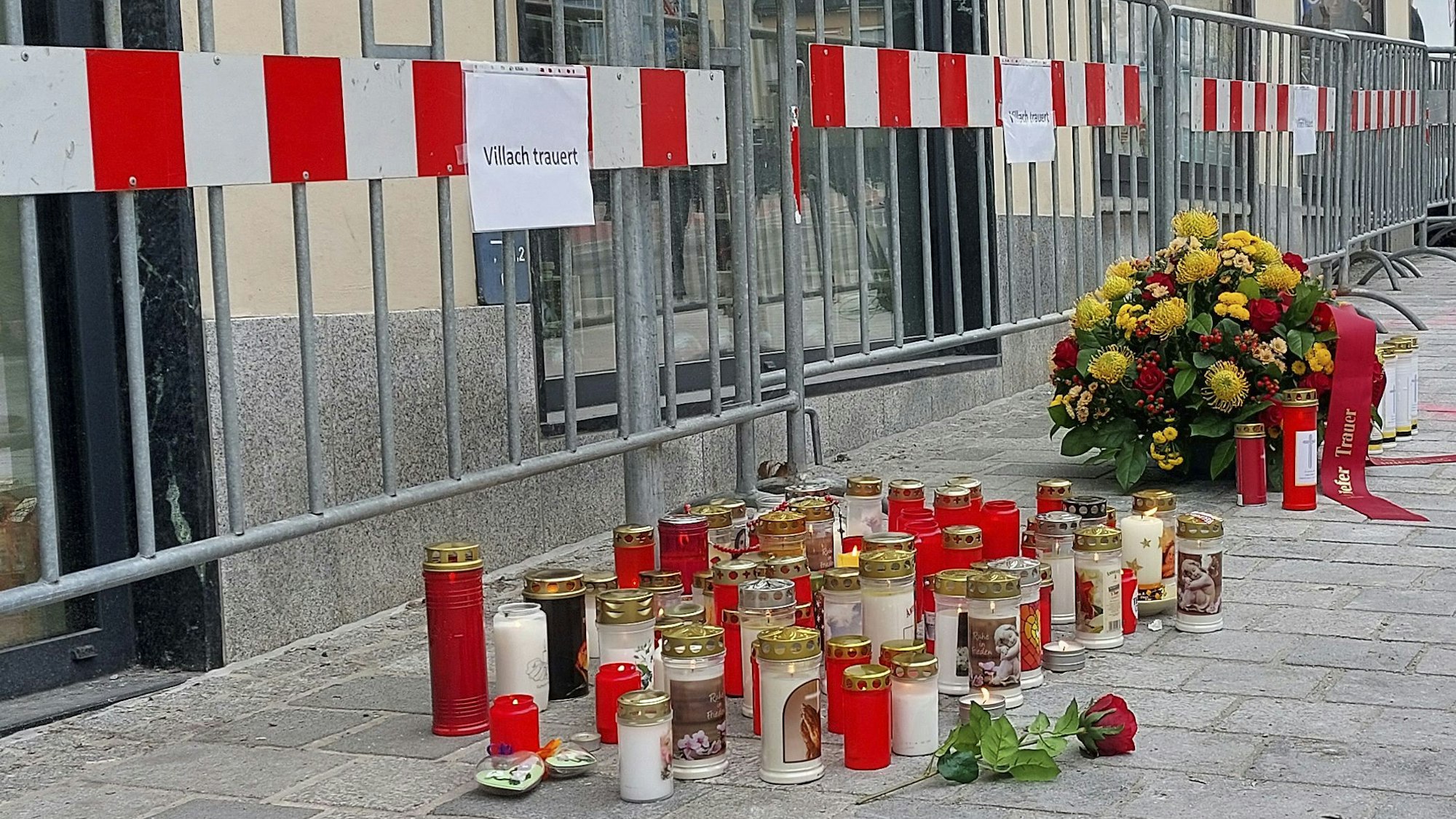 16.02.2025, Österreich, Villach: Blumen und Kerzen am Tatort des Messerangriffs. Ein Mann hat am Samstag, 15. Februar 2025, in Villach auf mehrere Passanten eingestochen und einen von ihnen getötet. Foto: Peter Lindner/APA/dpa +++ dpa-Bildfunk +++