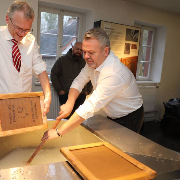 Butschas Bürgermeister Anatolii Fedoruk und Bergisch Gladbachs Bürgermeister Frank Stein schöpfen Papier im LVR-Industriemuseum Papiermühle Alte Dombach.